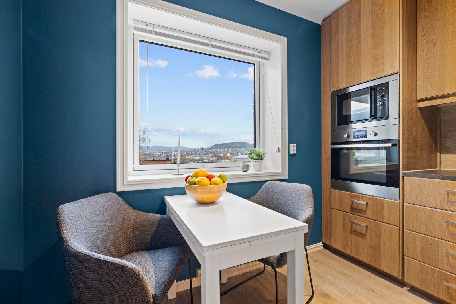 Et vindu gir fin utsikt mot byen og under vinduet er det plass til et frokostbord for to Galleribilde