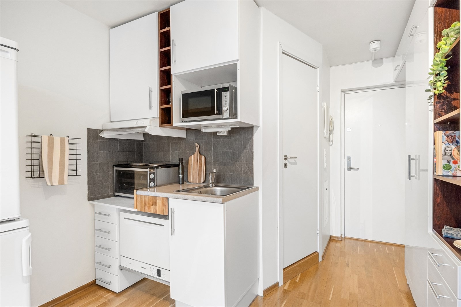 Pent kjøkken bestående av glatte fronter og laminat benkeplate med vaskekum. Opplegg for oppvaskmaskin. Galleribilde