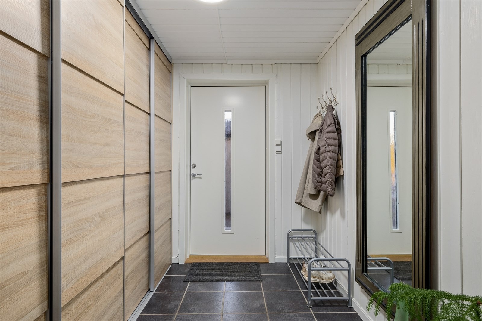 Lys og delikat entrè med god plass til oppheng av yttertøy og sko. Galleribilde