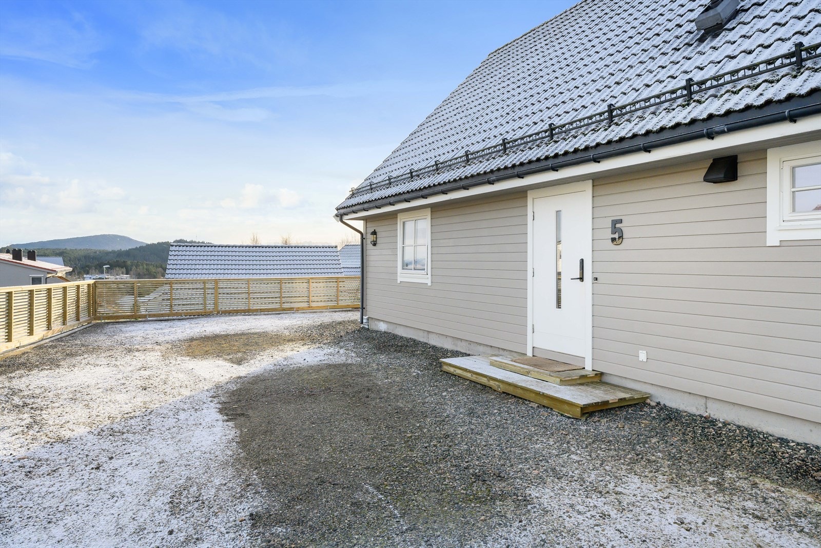 Gruset innkjørsel og parkering like ved inngangsdør. Galleribilde