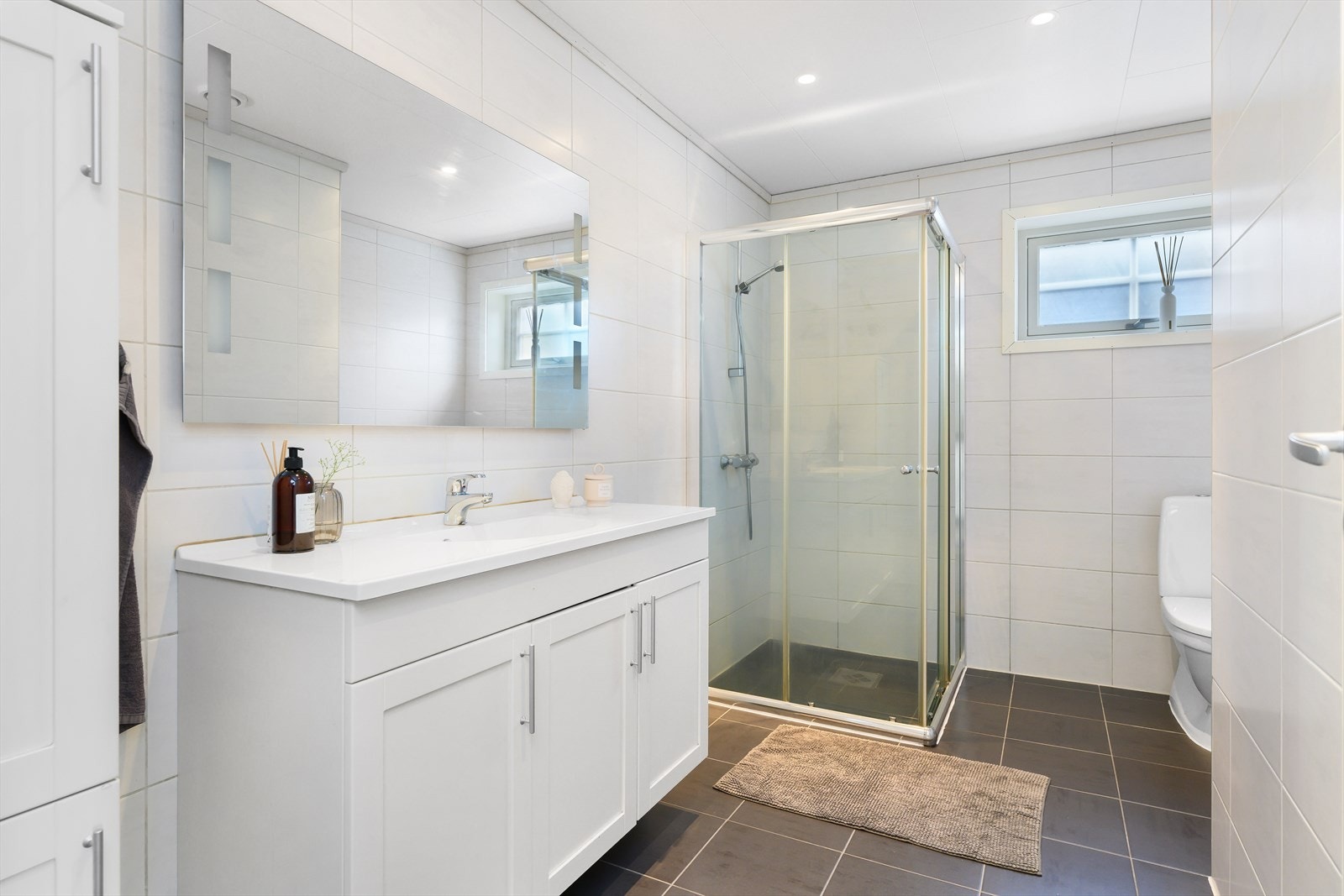 Badet er innredet med dusjvegger, servantinnredning med underskap, samt wc. Galleribilde