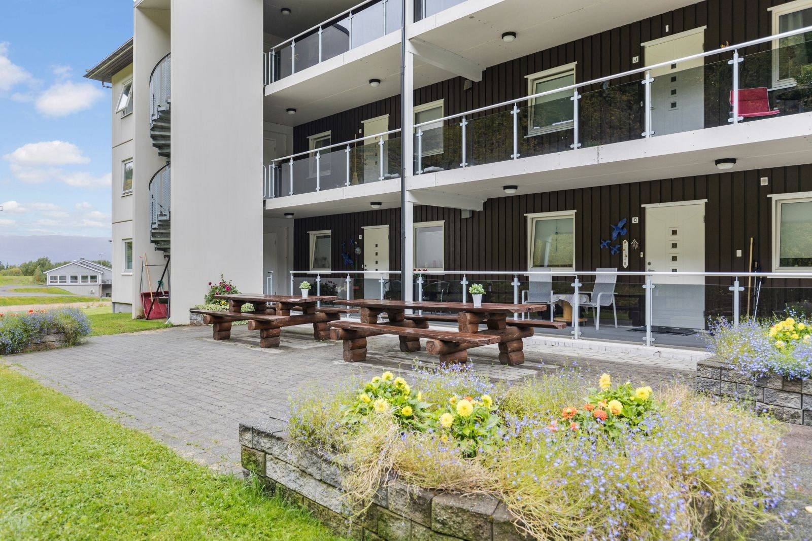 Koselige uteområder med sittebenker, brostein og beplantning. Galleribilde