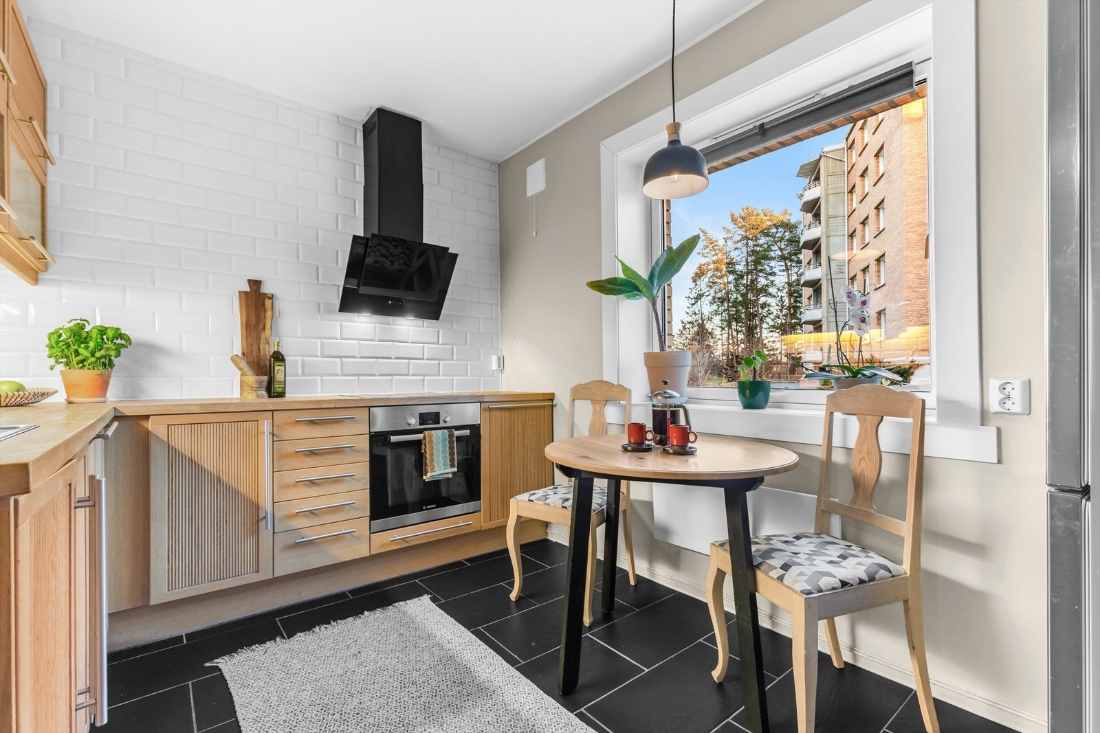 IKEA kjøkkeninnredning med profilerte fronter, heltre benkeplate med nedfelt vaskekum, samt fliser og belysning over benkeplaten. Galleribilde