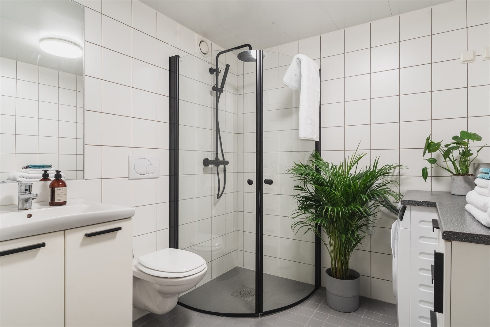 Pent helfliset baderom med varme i gulv og opplegg for vaskemaskin Galleribilde