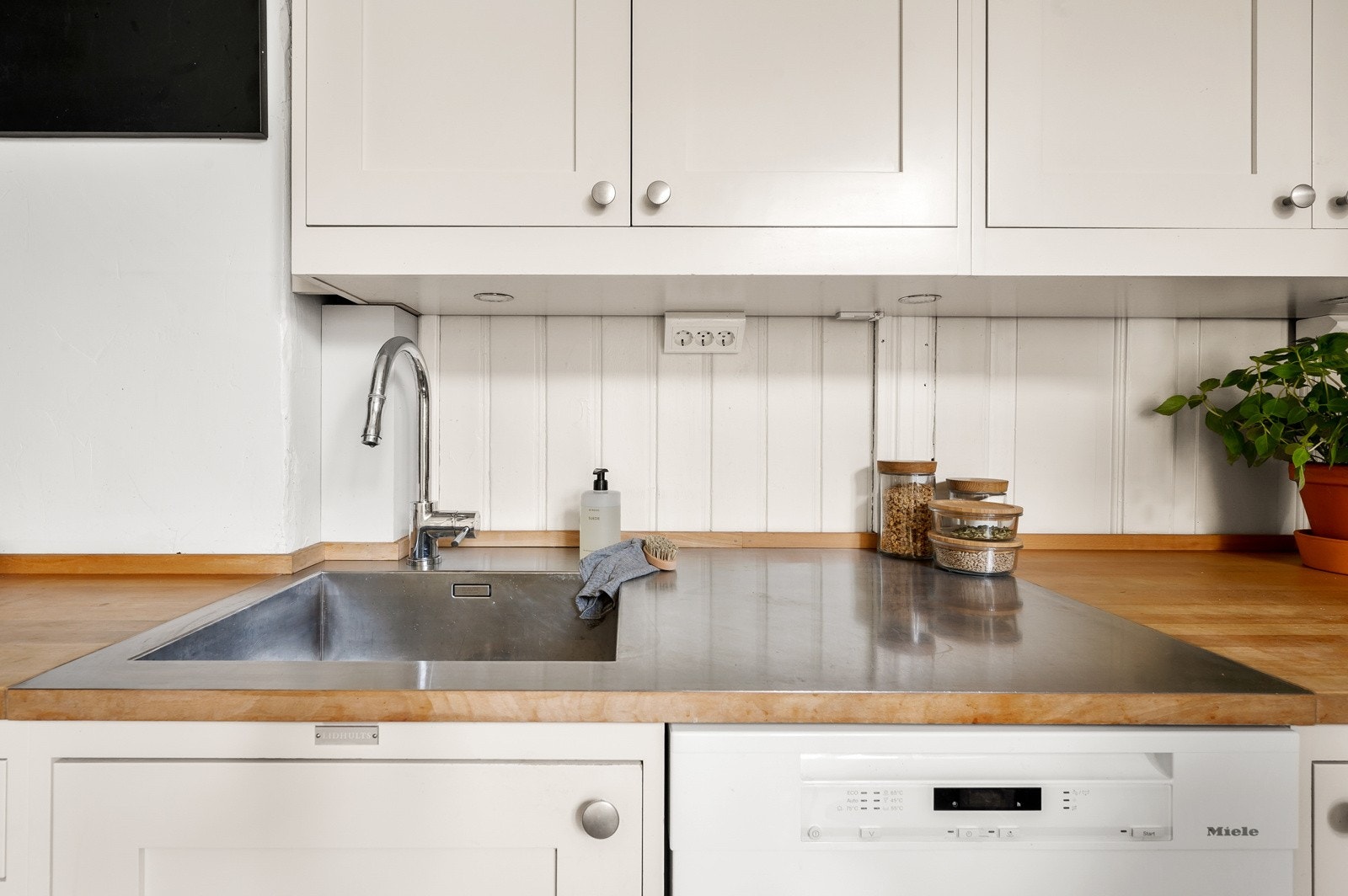 Super løsning ved oppvaskkummen som gjør det enklere å bevare de fine benkeplatene av tre. Galleribilde