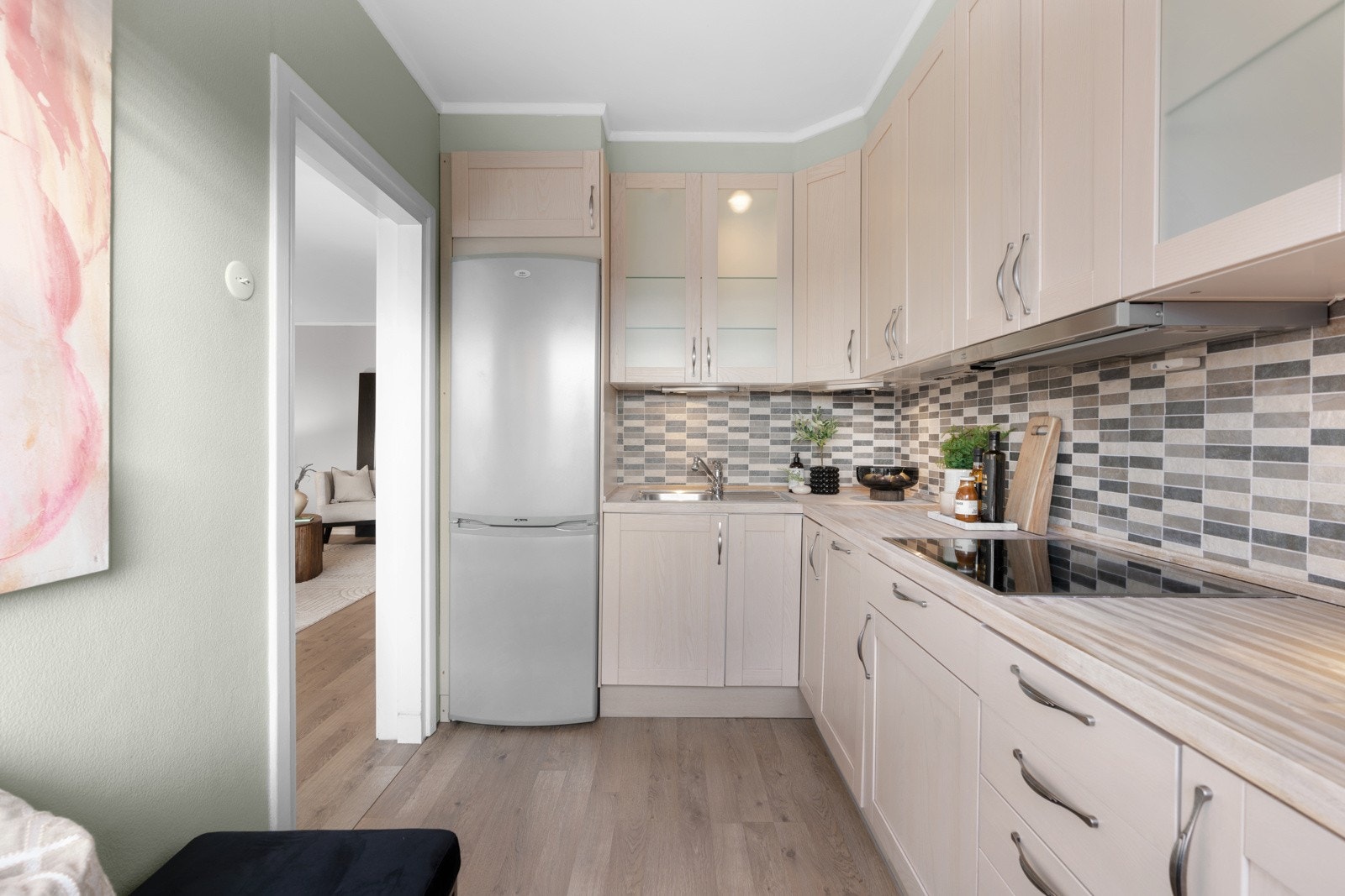 Over benken er det belysning og over kokesonen en ventilator, og en komfyrvakt. Integrert i innredningen er det platetopp, stekeovn og oppvaskmaskin. Galleribilde