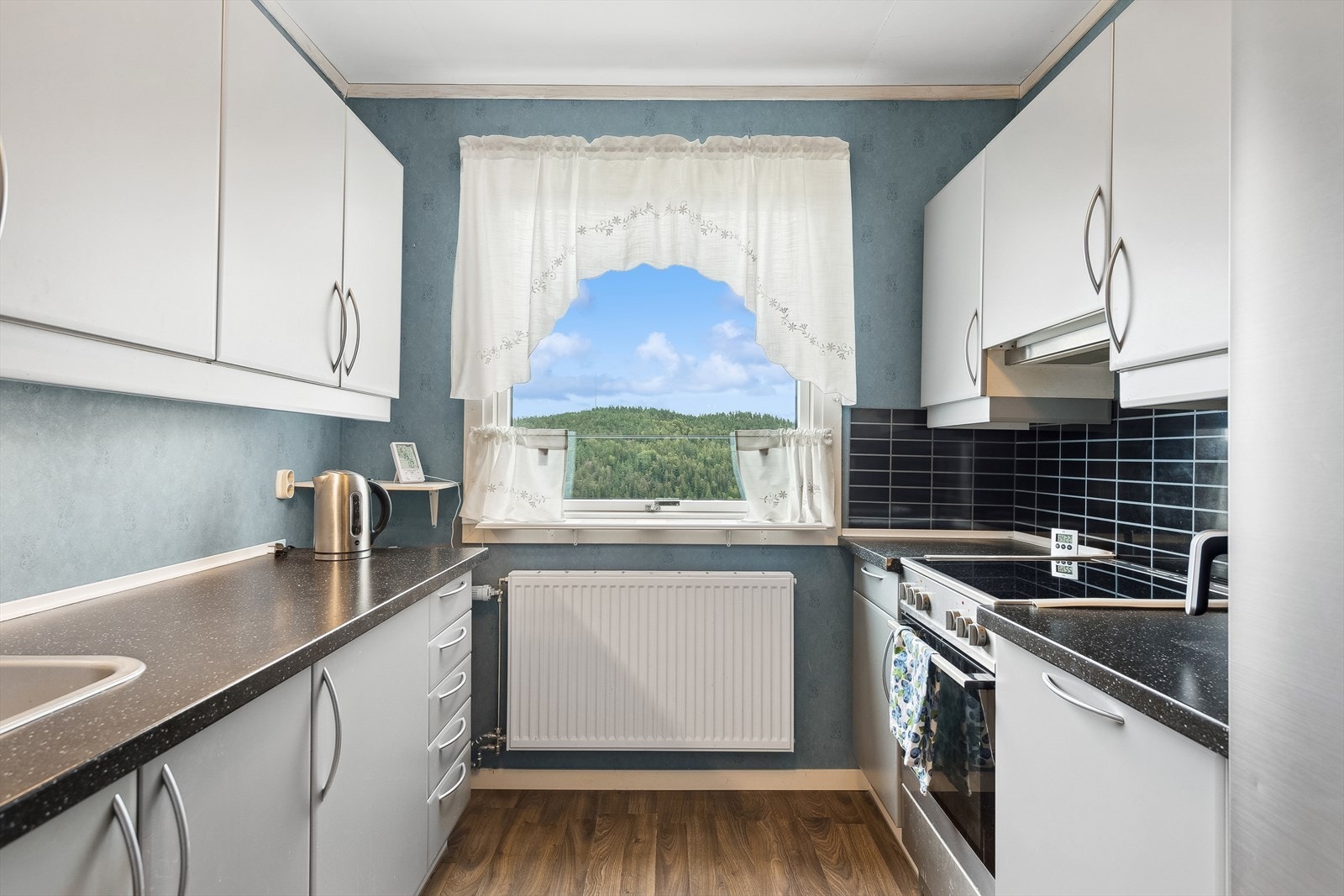 Lys og moderne kjøkkenløsning med god benkeplass og vindu Galleribilde