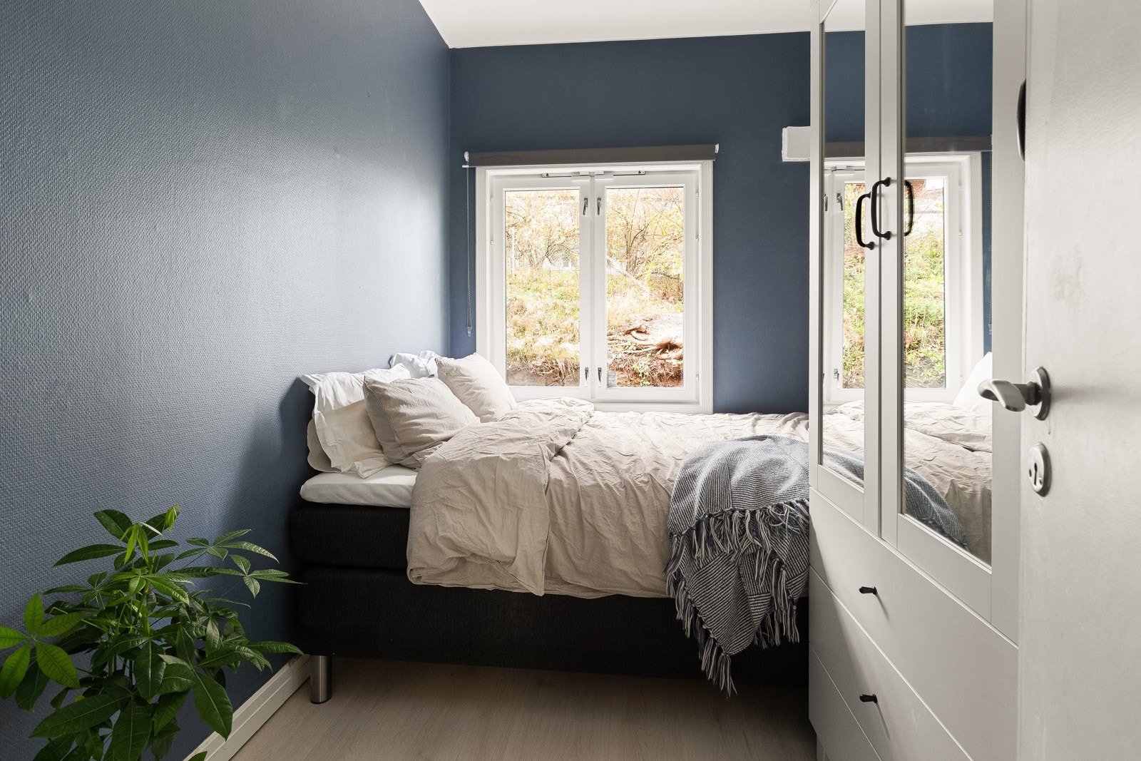 Innbydende soverom med plass til dobbeltseng, nattbord og garderobeløsning. Rommet er malt i en mørk farge som skaper en lun atmosfære gjennom alle årets sesonger. Fra soverommet er det tilgang til brannbalkong. Galleribilde