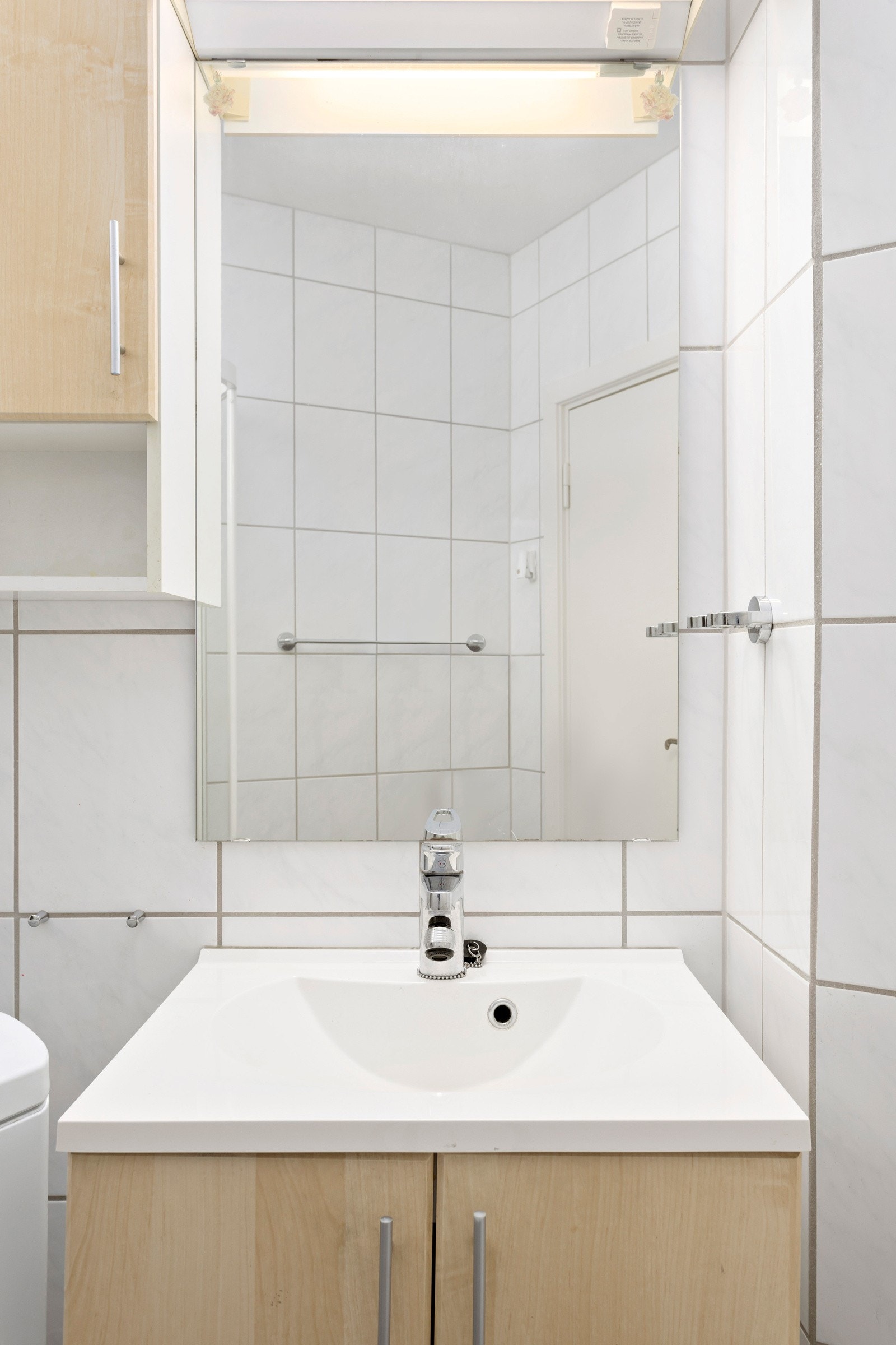 Badet er innredet med servant med underskap, speil, klosett og dusjsone Galleribilde