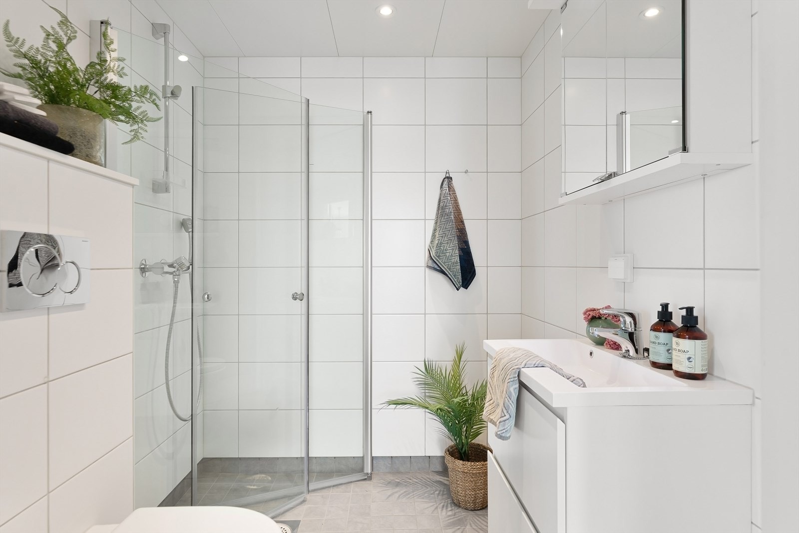 Leiligheten har 2 lekre baderom med hvite fliser på vegger og grå gulvfliser med termostatstyrt varmekabler. Galleribilde