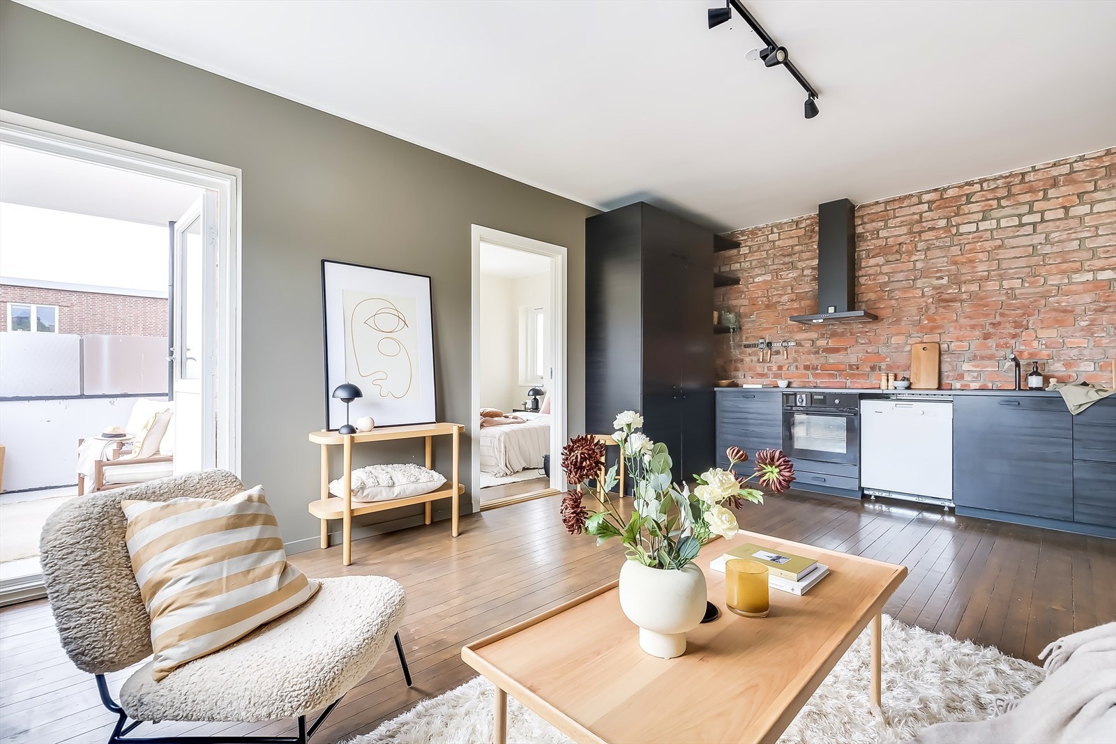 Den åpne løsningen mellom stue og kjøkken gir et sosialt oppholdsrom og en luftig atmosfære Galleribilde