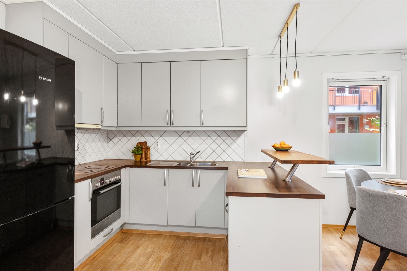 Kjøkkenet har glatte fronter, laminatbenkeplate og nedfelt oppvaskkum i rustfritt stål med ettgreps, svingbart blandebatteri i krom. Galleribilde