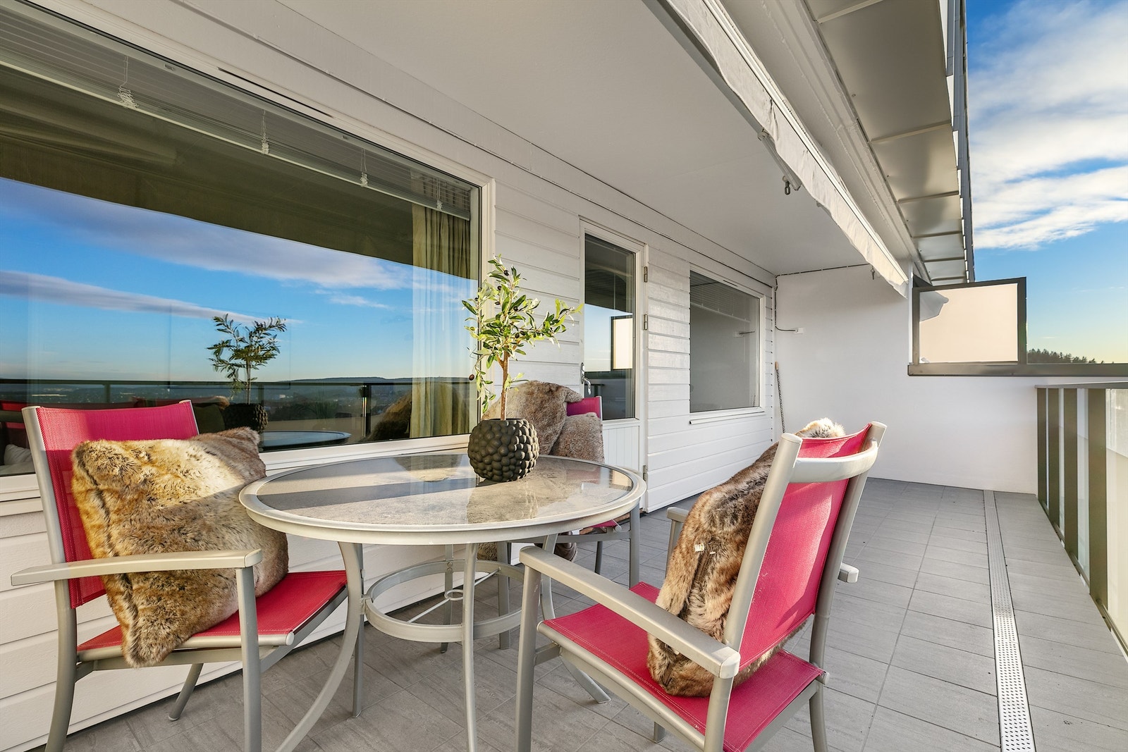 Nyrenovert terrasse med flislagt gulv og glassrekkverk Galleribilde