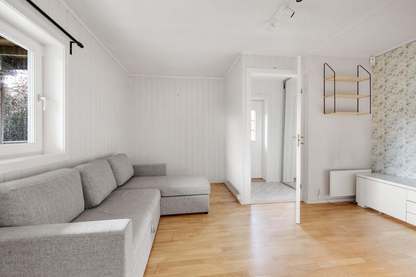 Lys og romslig stue med malte overflater og trestavs parkett på gulv. Galleribilde
