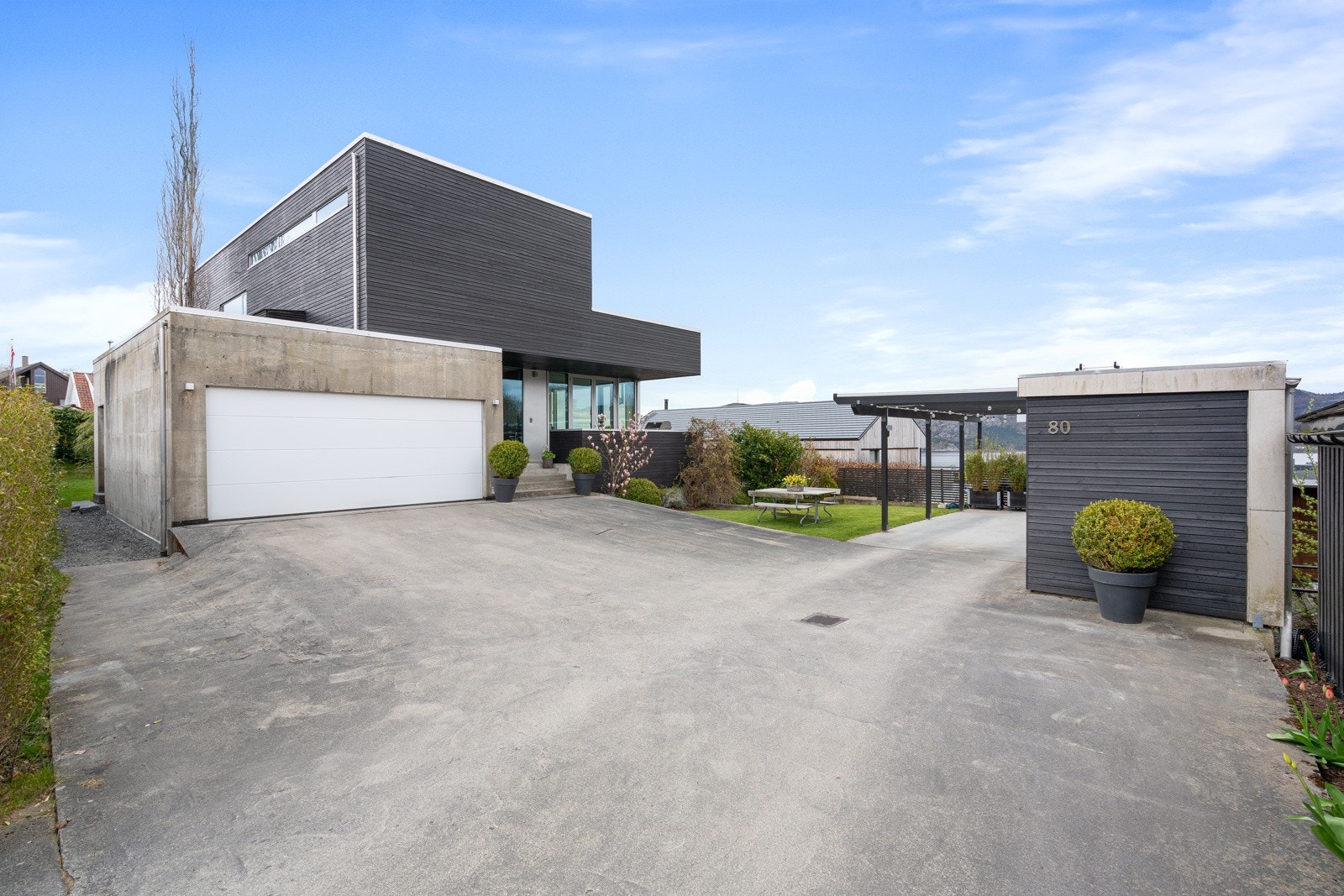 Integrert dobbel garasje og carport. Carporten kan også benyttes til sosiale sammenkomster og skjermer for vær og vind. Galleribilde