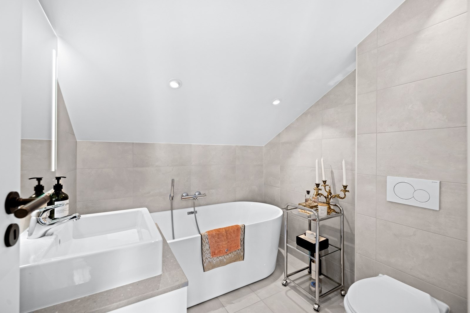 Lekkert, flislagt baderom med eget design badekar og stilren innredning fra Kvänum. Det er også downlights i tak og varmekabler i gulvet. Galleribilde