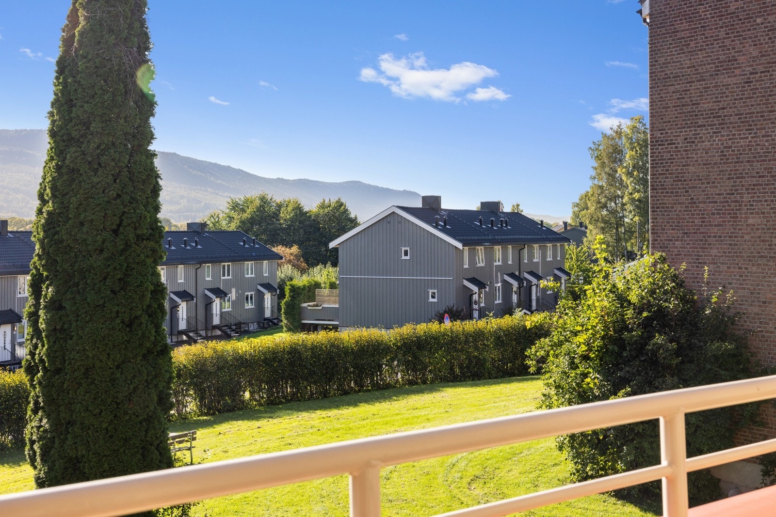 Fra balkongen ser man ut over hagen som er en del av fellesarealene Galleribilde