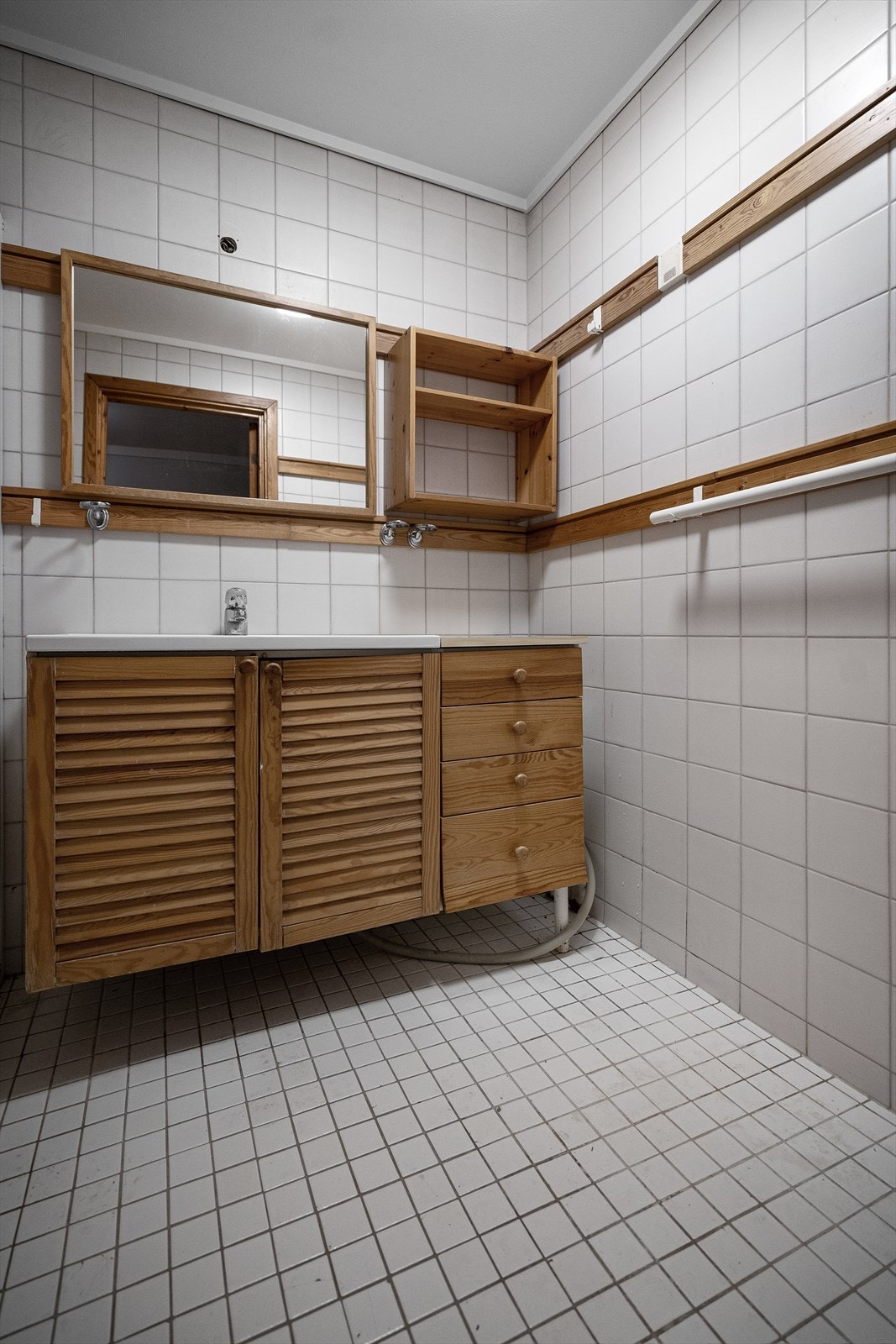 Baderommet er utstyrt med baderomsinnredning med servant, speil, hyller, dusjhjørne og opplegg for vaskemaskin. Galleribilde