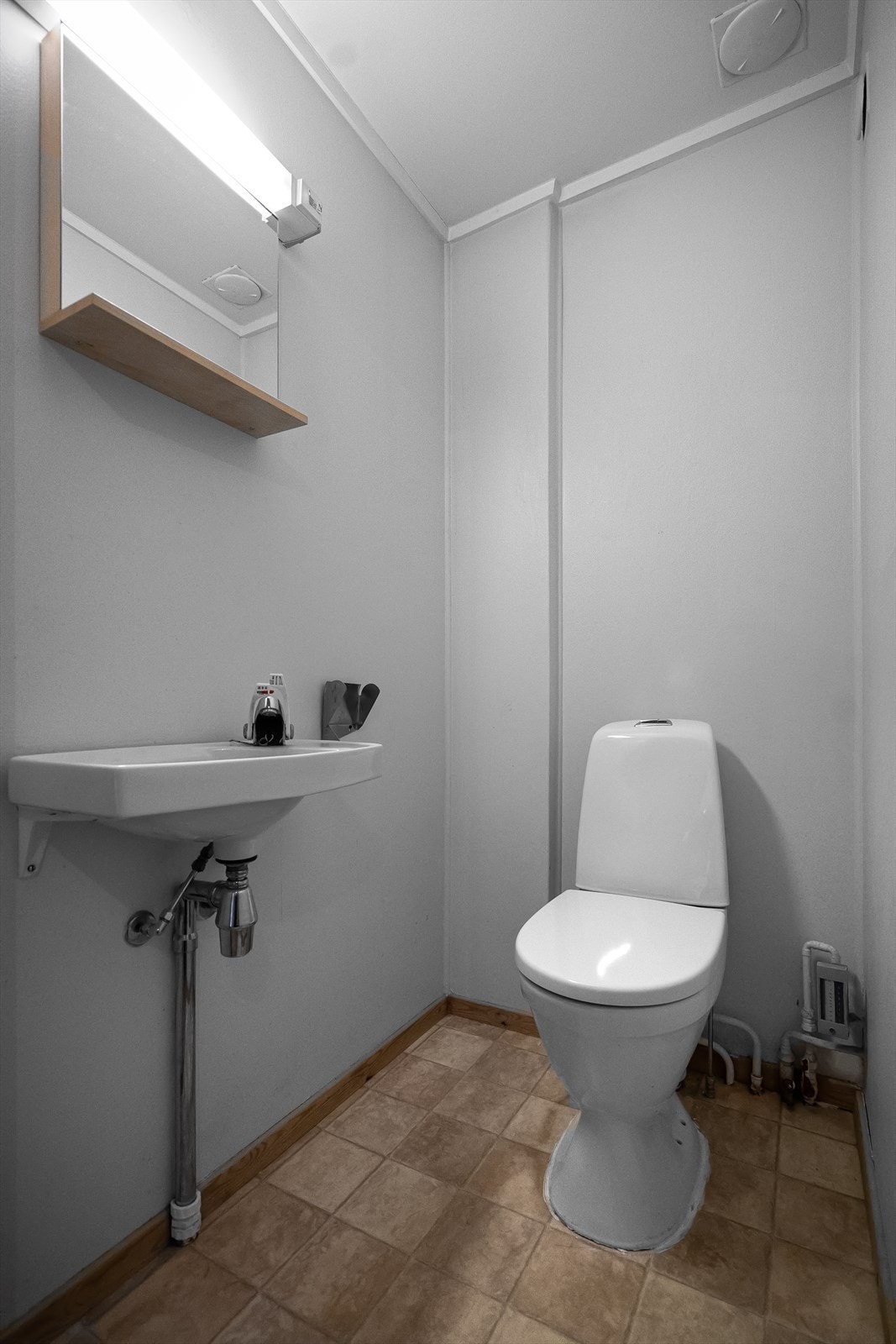 Vegg-i-vegg med baderommet har du et praktisk separat toalettrom. Rommet har belegg på gulv og er utstyrt med vegghengt servant, speil og belysning over, samt gulvstående toalett. Galleribilde