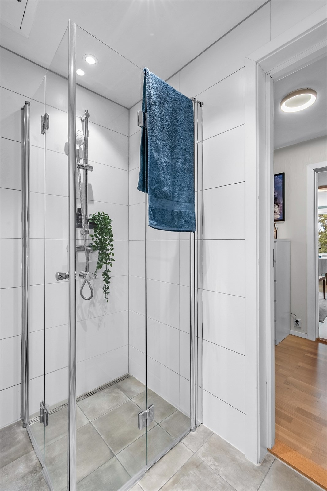 Justerbare dusjdører er satt inn for å utnytte plassen maksimalt. Opplegg til vaskemaskin på baderom. Galleribilde