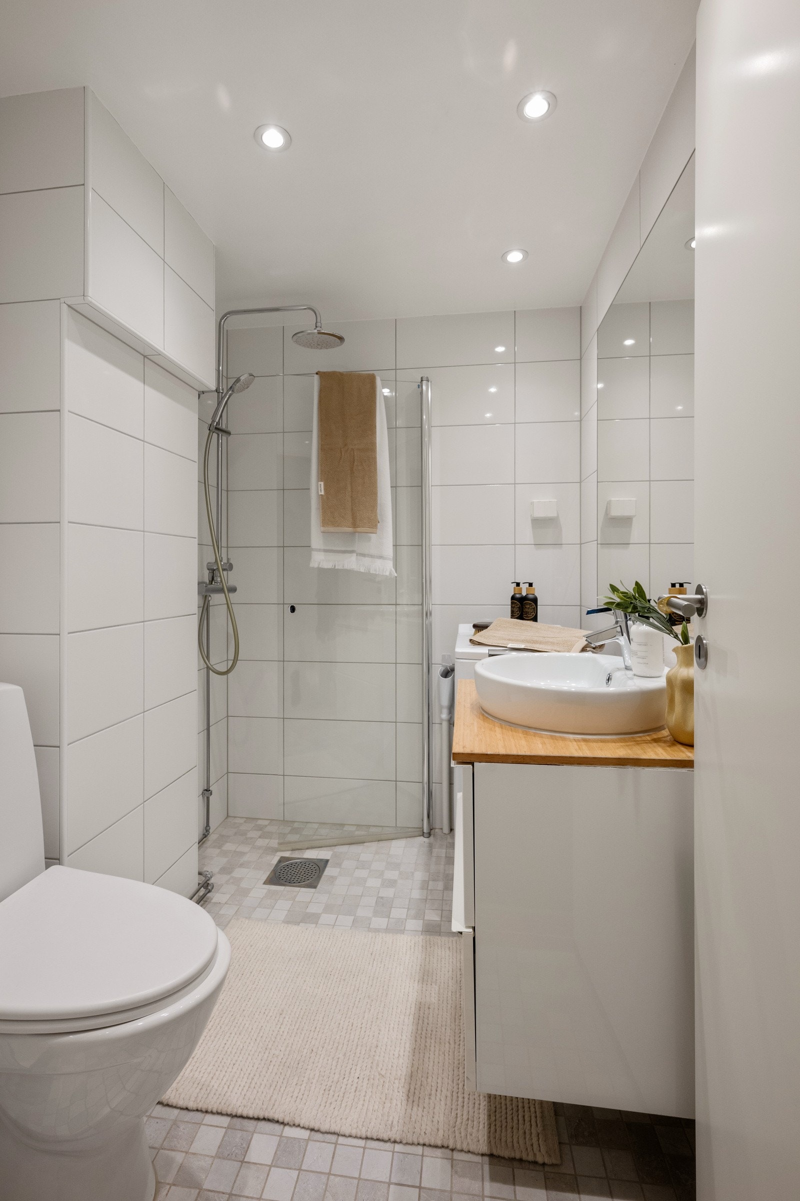 Pent bad med flislagte overflater, varmekabler i gulv og opplegg for vaskemaskin. Galleribilde