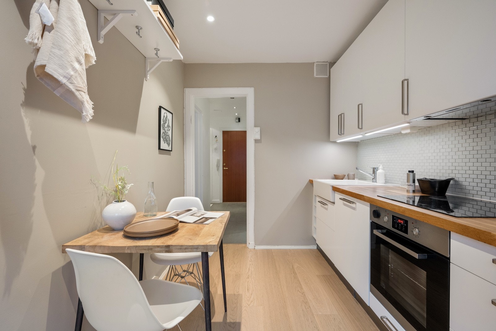 Stilren kjøkkeninnredning med glatte fronter og heltre benkeplate med kum i porselen. Galleribilde