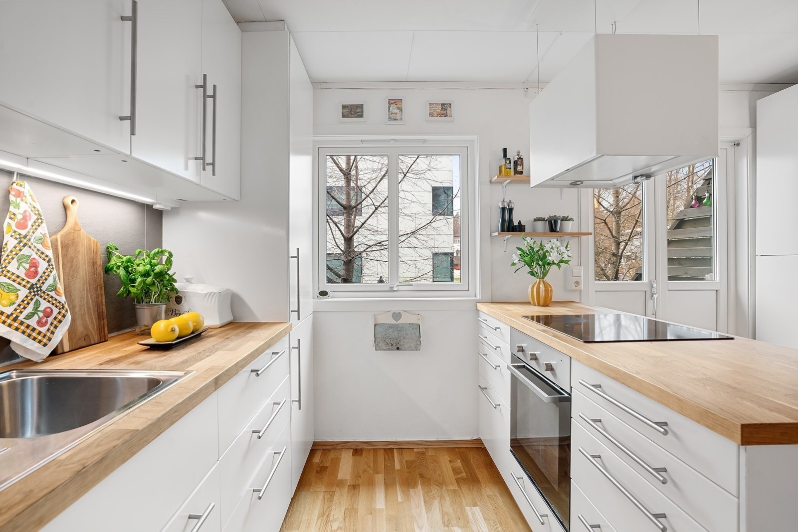 Kjøkkenet har integrerte hvitevarer og godt med skapplass. De store vindusflatene gir godt med naturlig lysinnslipp til rommet. Galleribilde