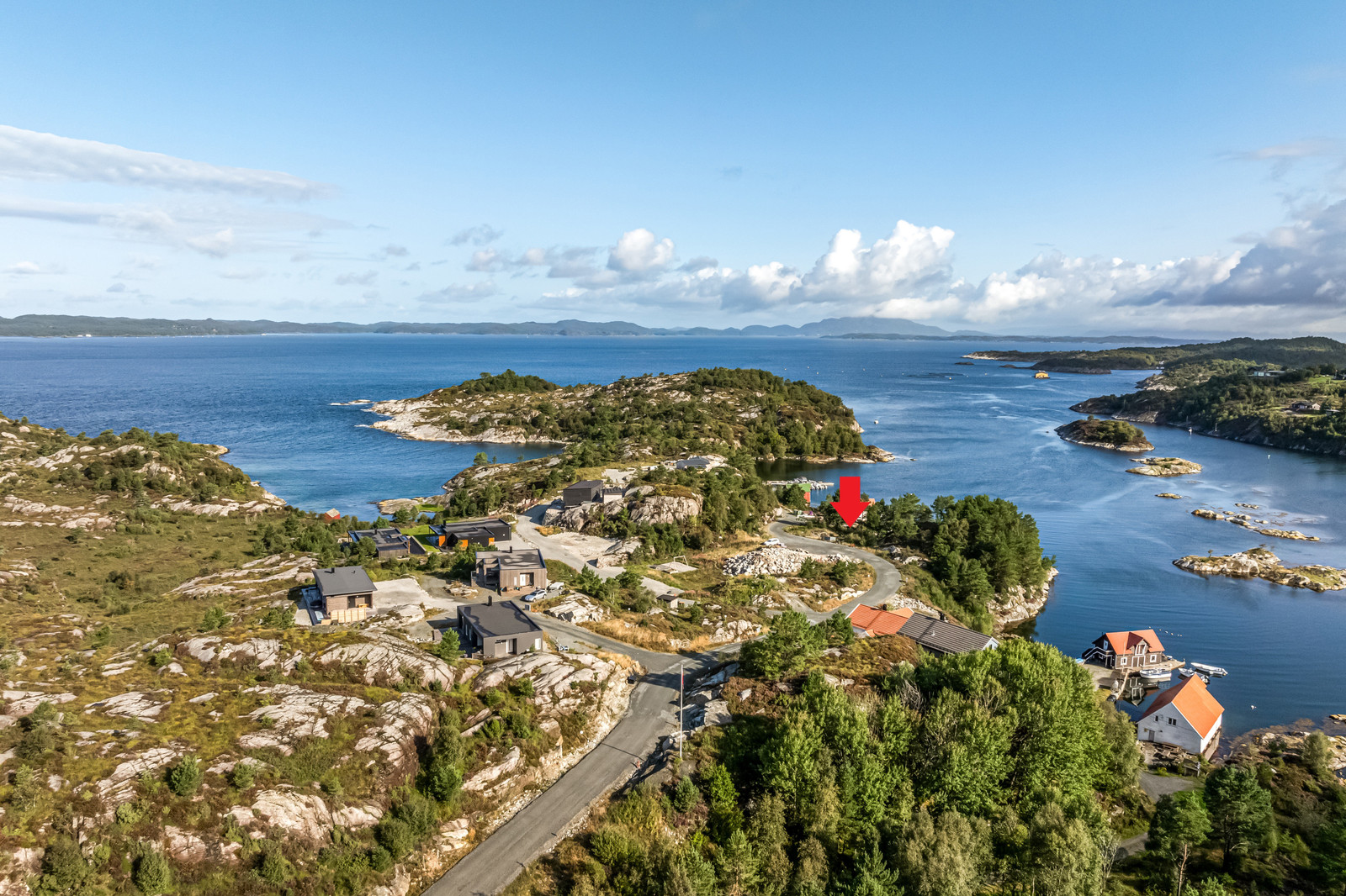 Tomta ligger helt til sjøen i enden av veien, en av de beste tomtene på feltet! Tomta markert med rød pil på bilde - tatt sommer 2024