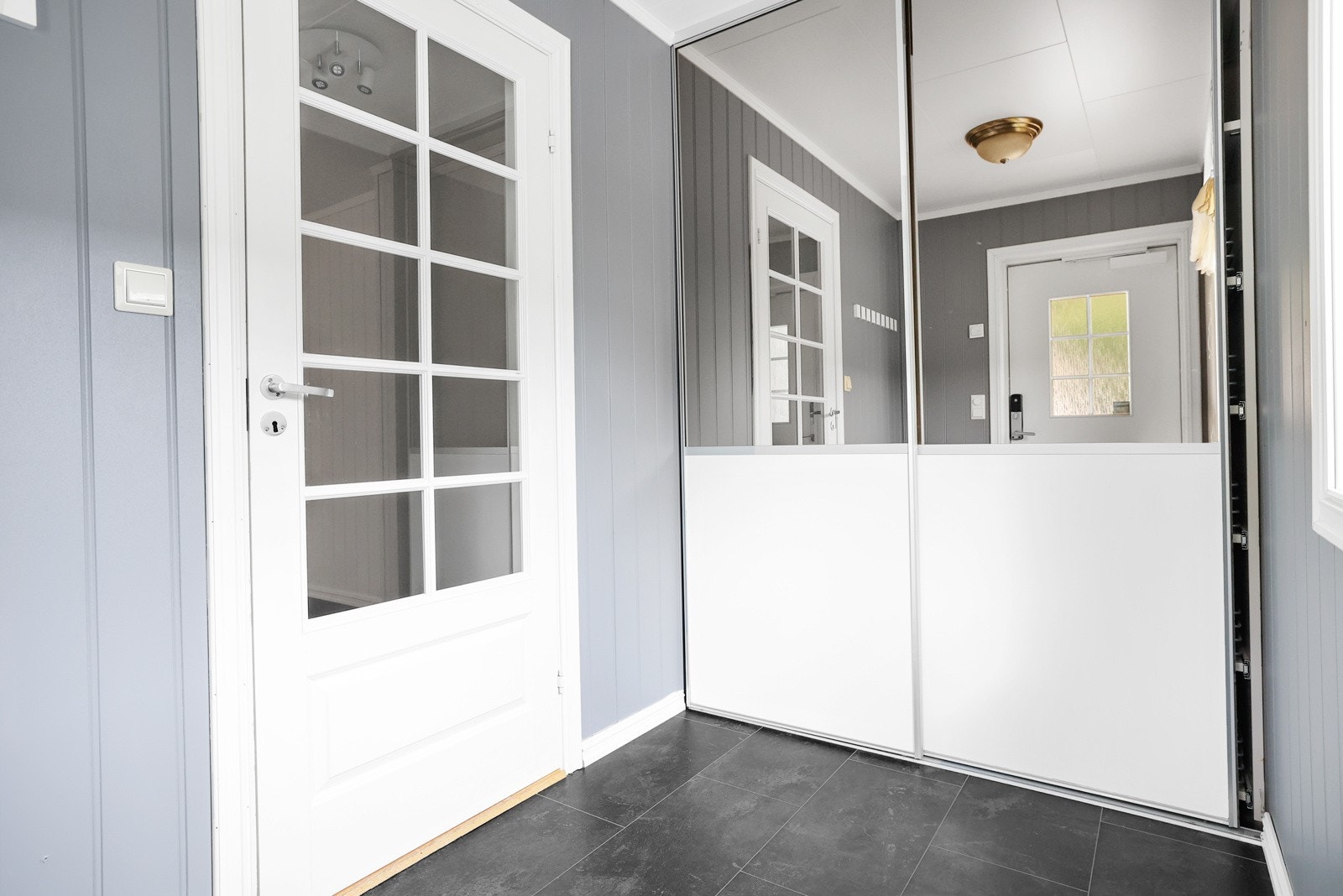 Entréen har en stor skyvedørsgarderobe med speil som gir god oppbevaringsplass Galleribilde