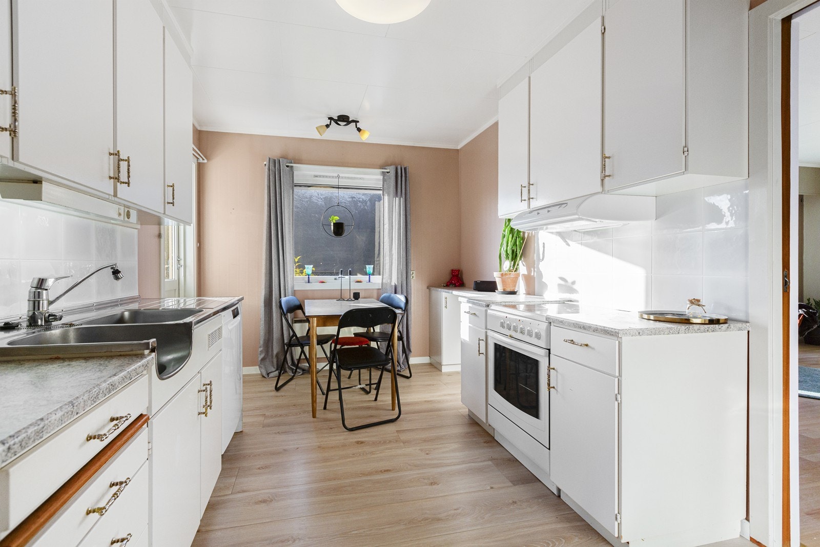 Kjøkkeninnredning med profilerte fronter, laminert benkeplate med nedfelt oppvaskkum. Hvitevarer som kjøleskap, og oppvaskmaskin. Galleribilde