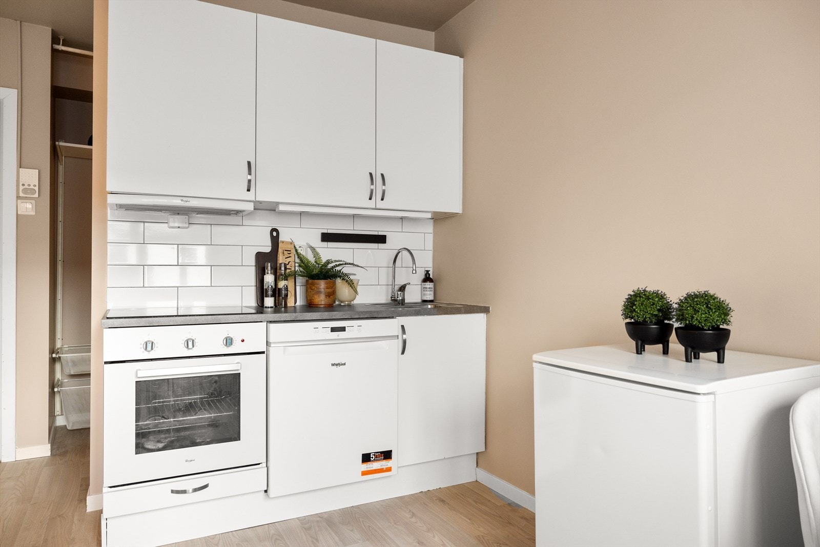 Kjøkkenet er utstyrt med en kum med ettgreps blandebatteri, kullfiltervifte over integrert koketopp og stekeovn, samt oppvaskmaskin. Galleribilde