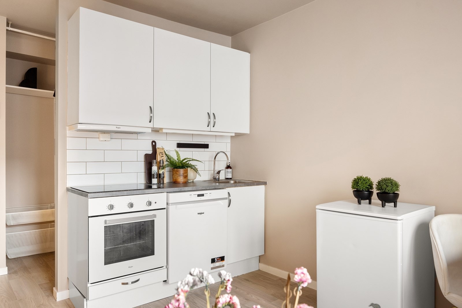 Moderne og stilren kjøkkeninnredning med glatte, laminerte fronter, fliser mellom overskapene og laminatbenkeplate. Galleribilde