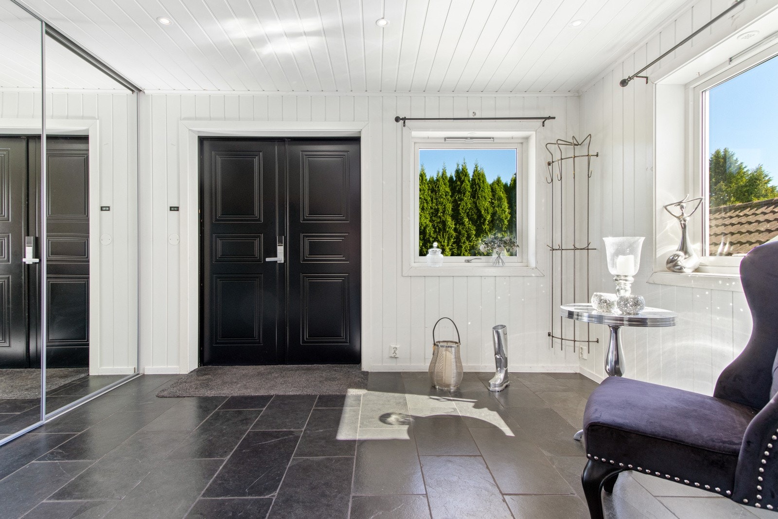 Vel inne har boligen en stor og innbydende entré med tilliggende hall, og begge rommene er innredet med varmekabler, downlights og store, sorte gulvfliser. Galleribilde