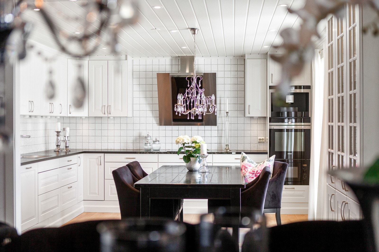 Over benken er det belysning og hvite fliser, og over kokesonen har kjøkkenet en stilig ventilator. Galleribilde