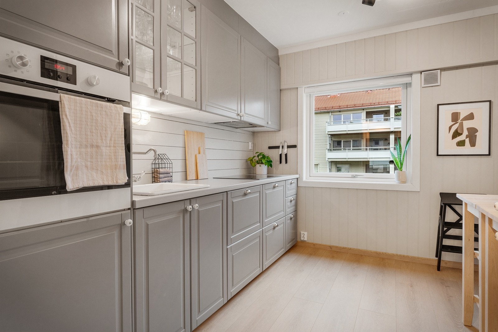 Innredning med profilerte fronter og laminat benkeplate med porselensvask. Galleribilde