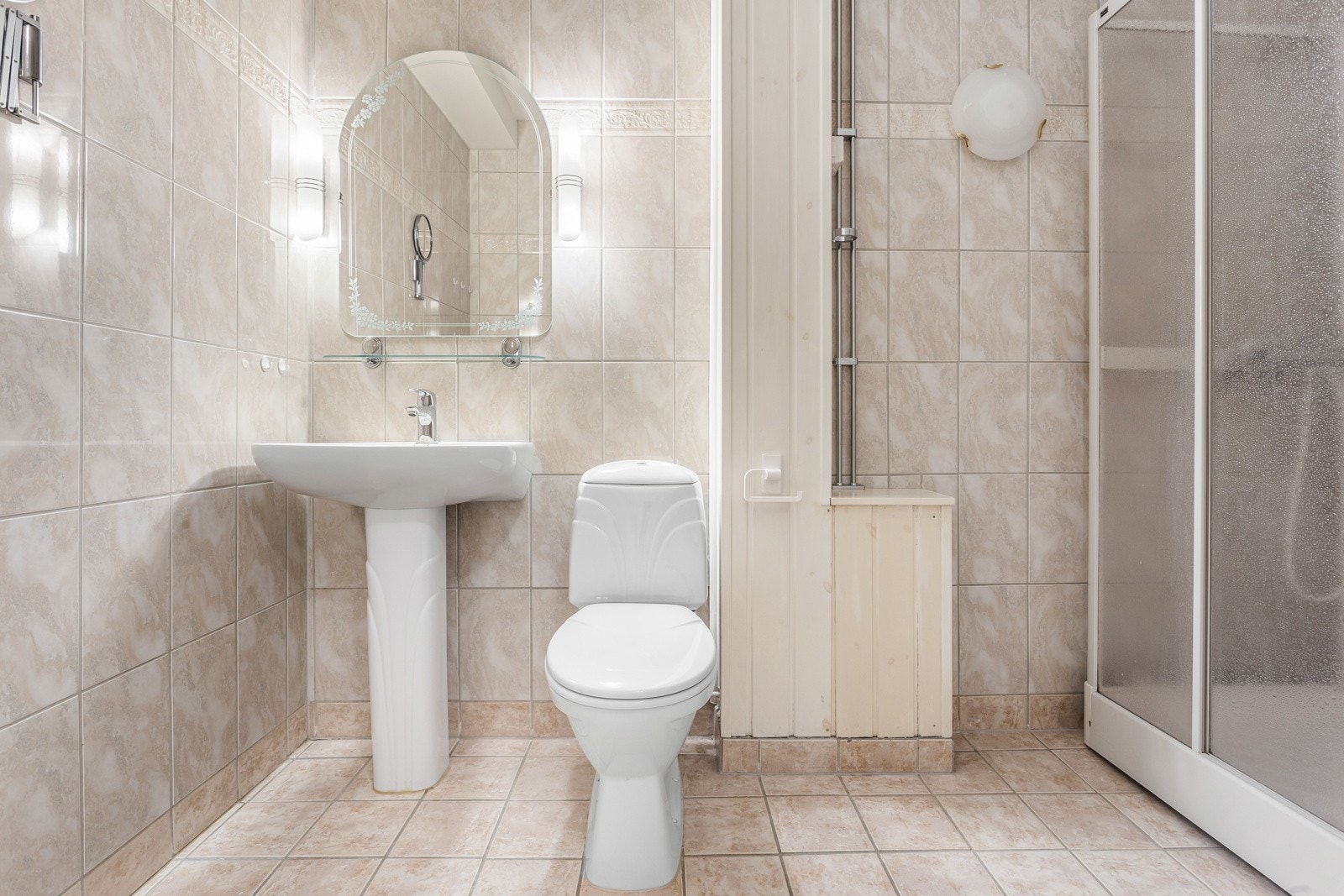 Eldre baderom bestående av toalett, dusjkabinett, servant og speil. Galleribilde