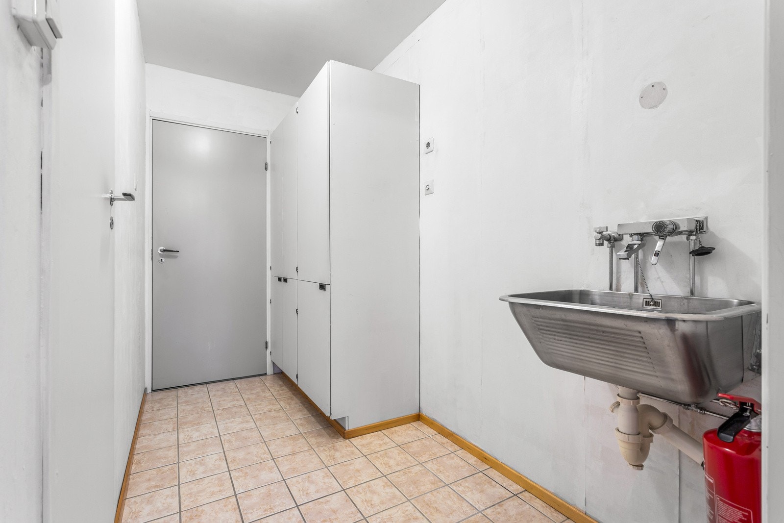 Mellomgang fungerende som vaskerom. Rommet er innredet meed utslagsvask og opplegg for vaskemaskin. Galleribilde