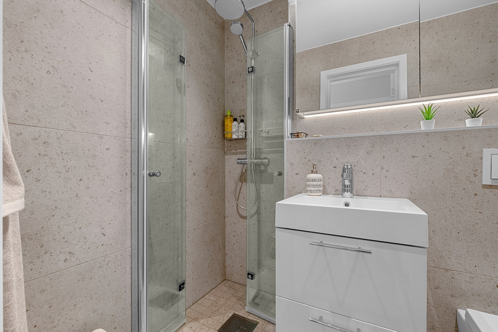 Badet byr på en rekke kvaliteter som behagelig varme i gulv, moderne baderomsinnredning og regndusjarmatur. Badet er vurdert til tilstandsgrad 0 av takstmann. Galleribilde