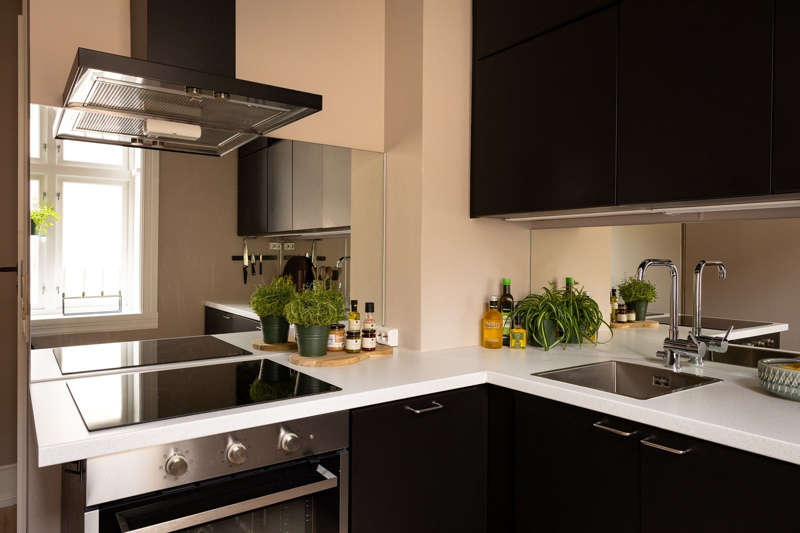 Innredningen går helt til taket og består av sorte, glatte fronter som gir kjøkkenet et moderne uttrykk Galleribilde