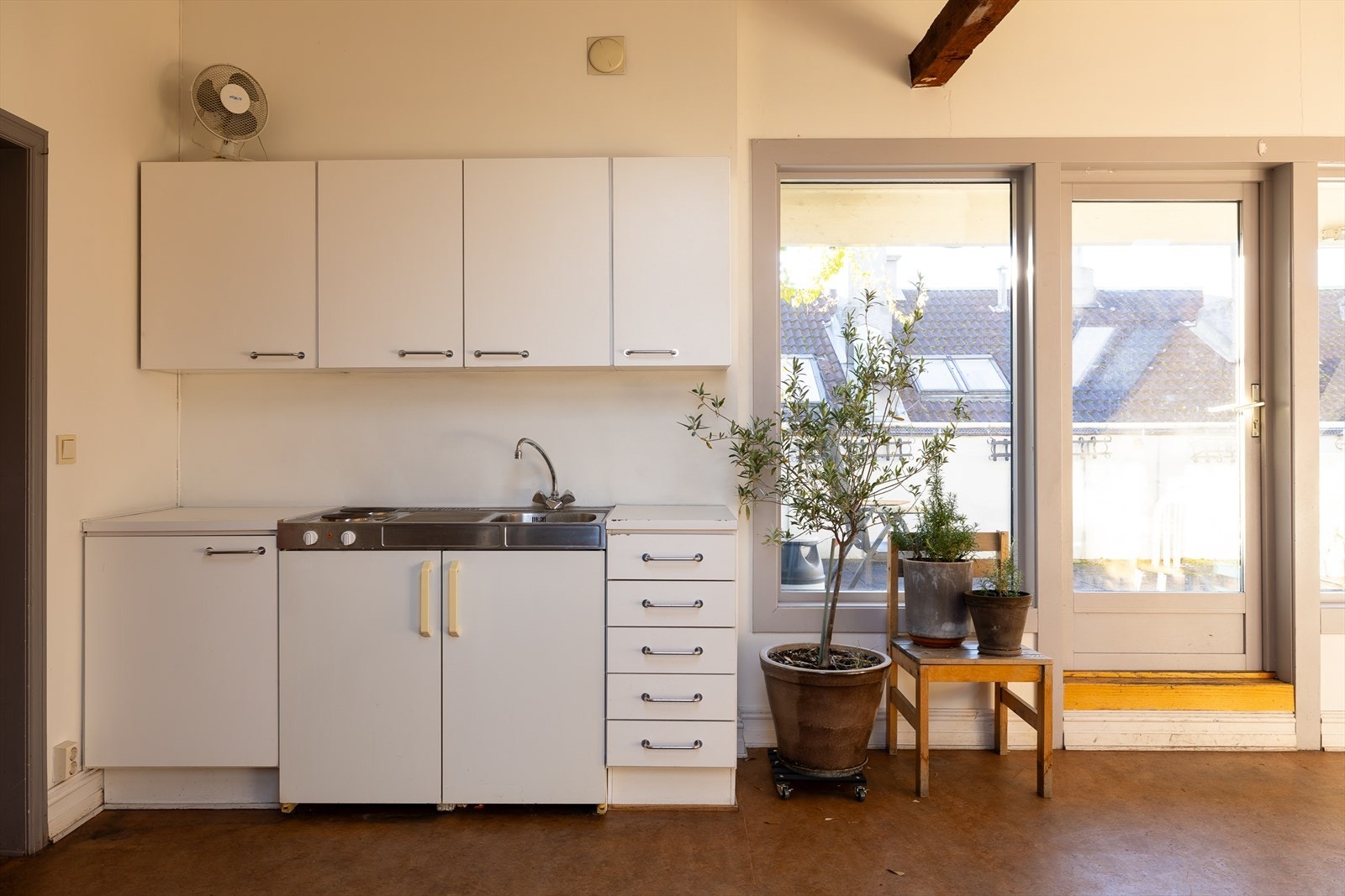 Lokalet har et kjøkken, og er innredet med langbord og sittegrupper Galleribilde