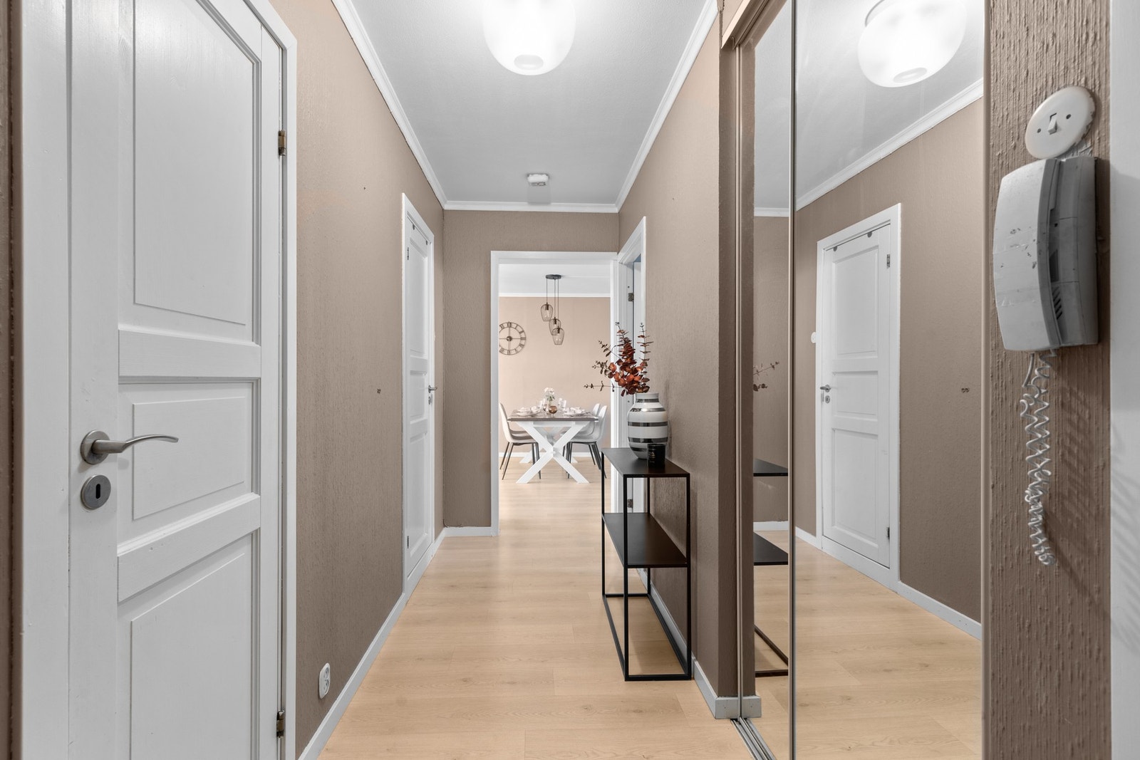Velkommen inn til en innbydende entré som ønsker velkommen hjem. Her er det en skyvedørsgarderobe med speil som gir god plass til sko og yttertøy, mens den pene, varme veggfargen skaper en hyggelig atmosfære. Galleribilde