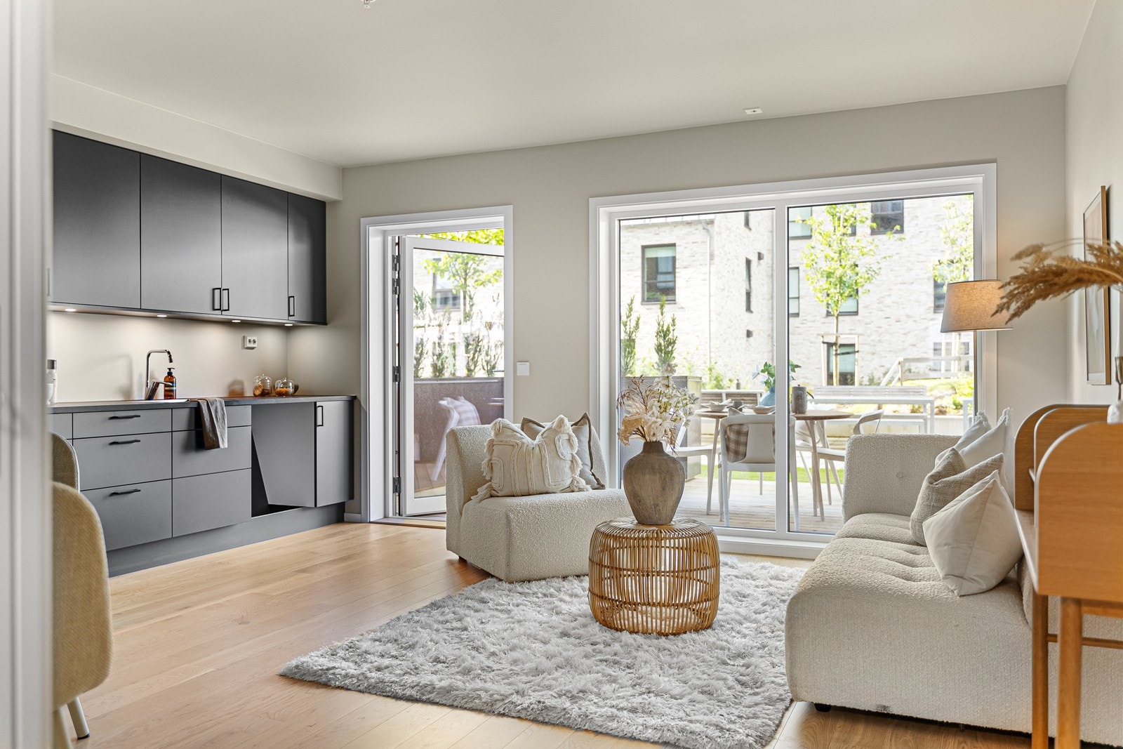 Leiligheten er lys og innbydende - Store vinduer i stuen som vender ut mot takhagen Galleribilde