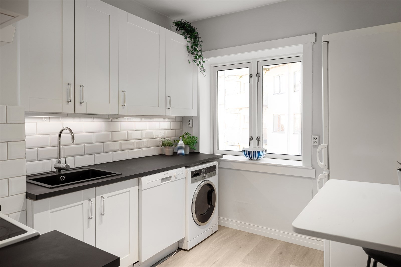 Separat kjøkken med tidløs innredning og plass til et lite spisebord. Galleribilde