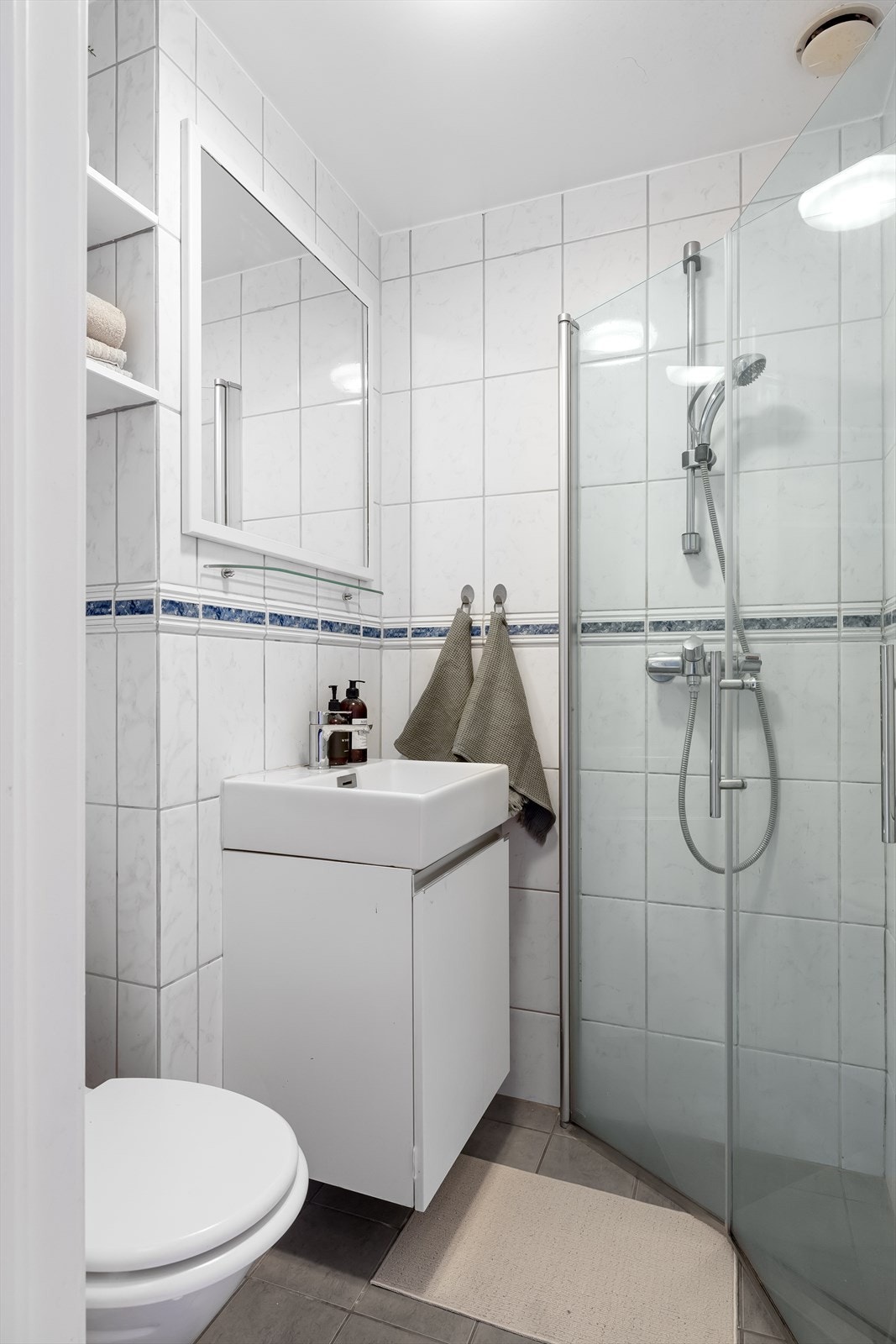 Badet består av dusjhjørne, servant og toalett. Galleribilde