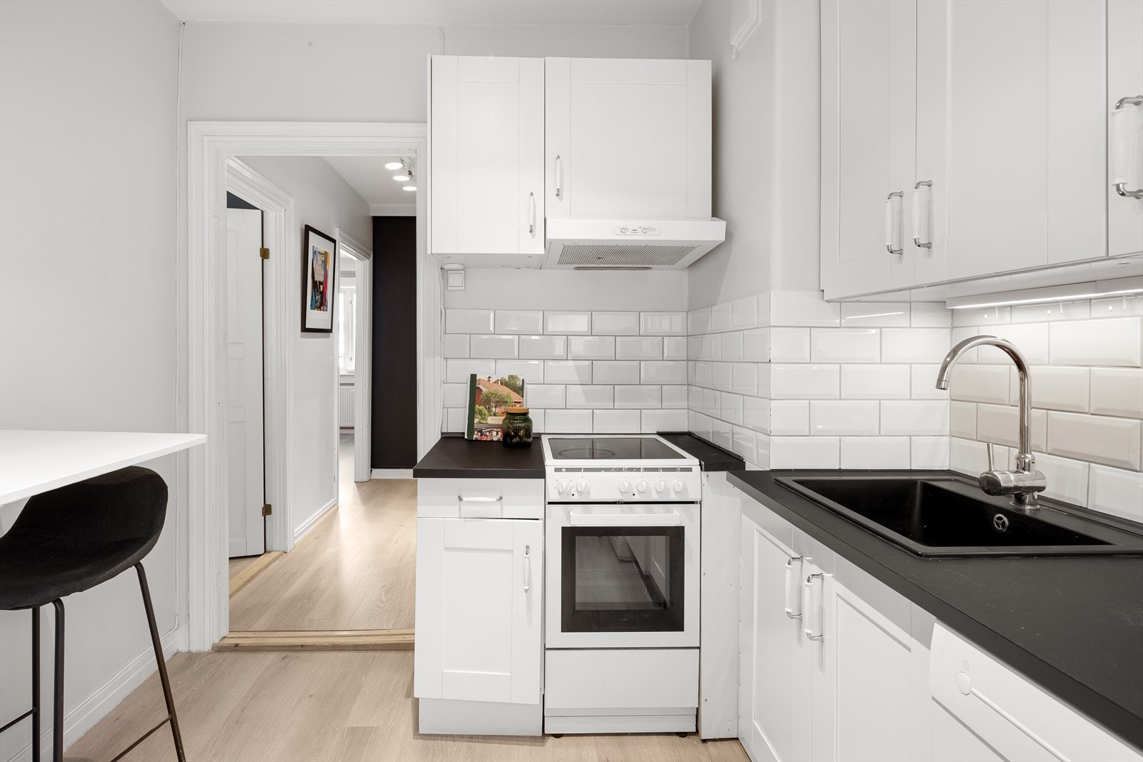 Kjøkkeninnredning med laminerte benkeplater, flislagt backsplash og profilerte fronter. Galleribilde