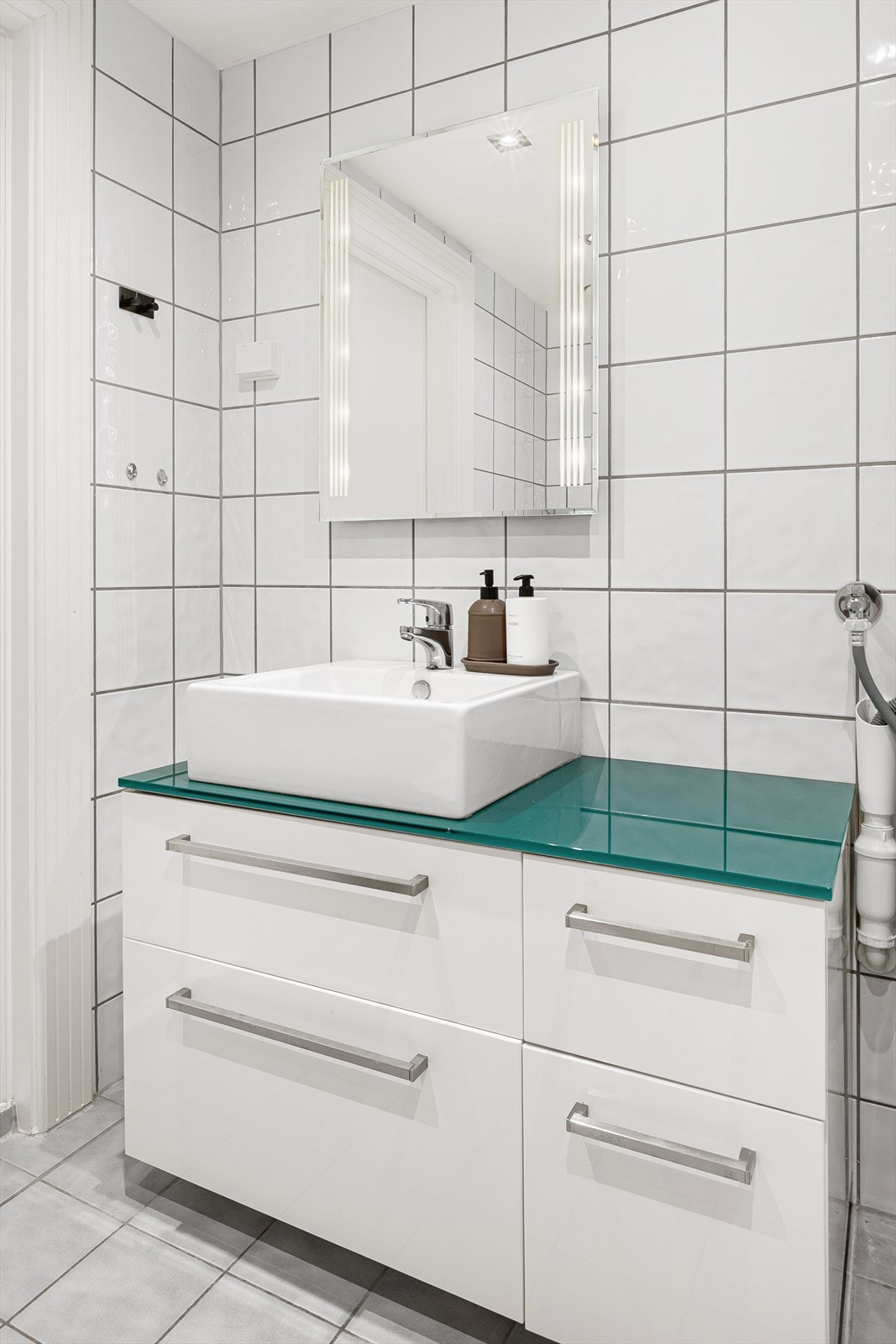 Badet har opplegg for vaskemaskin, samt servantinnredning, toalett og dusjhjørne Galleribilde