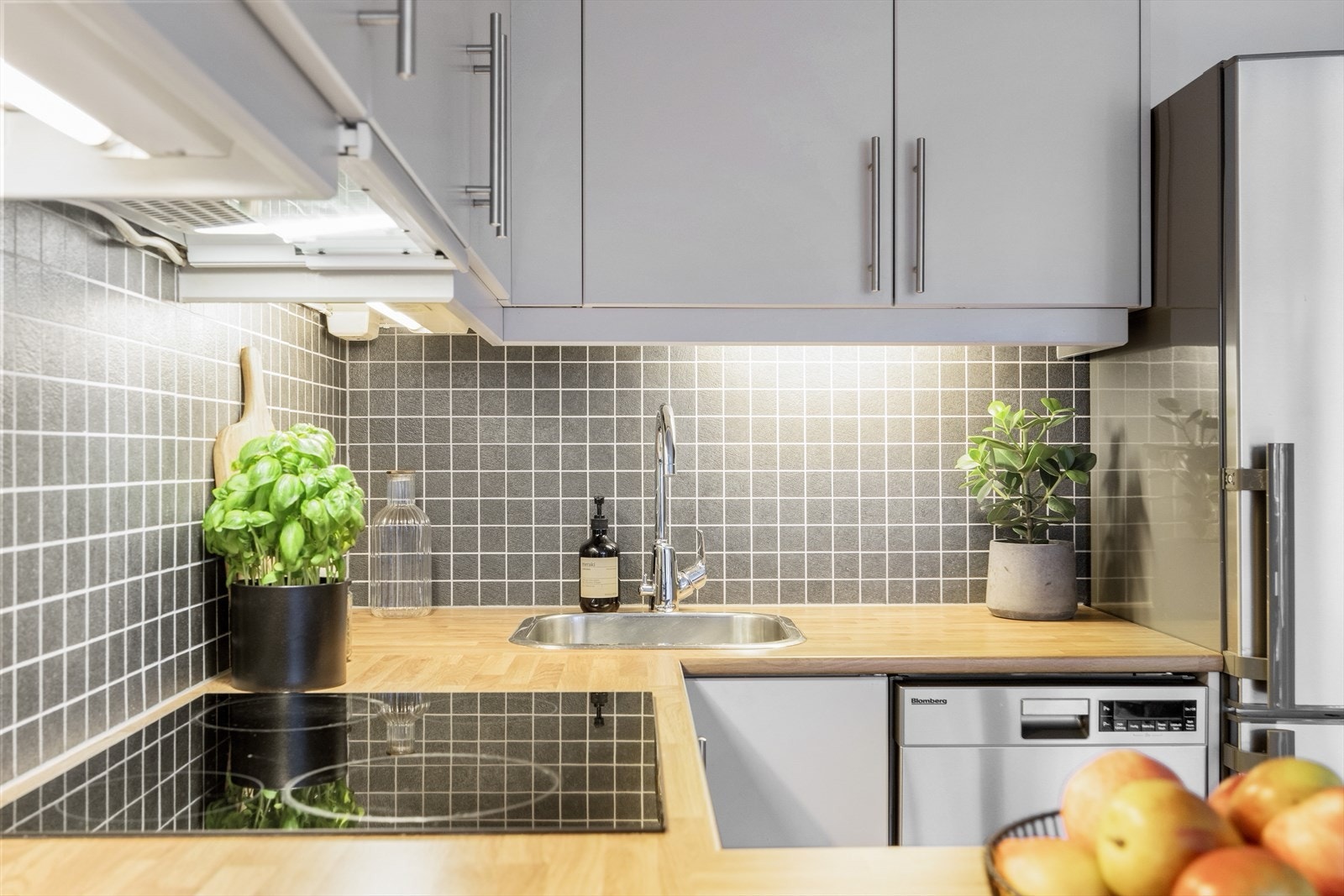 Kjøkkenet er utstyrt med kombiskap, oppvaskmaskin, integrert komfyr og nedfelt platetopp Galleribilde