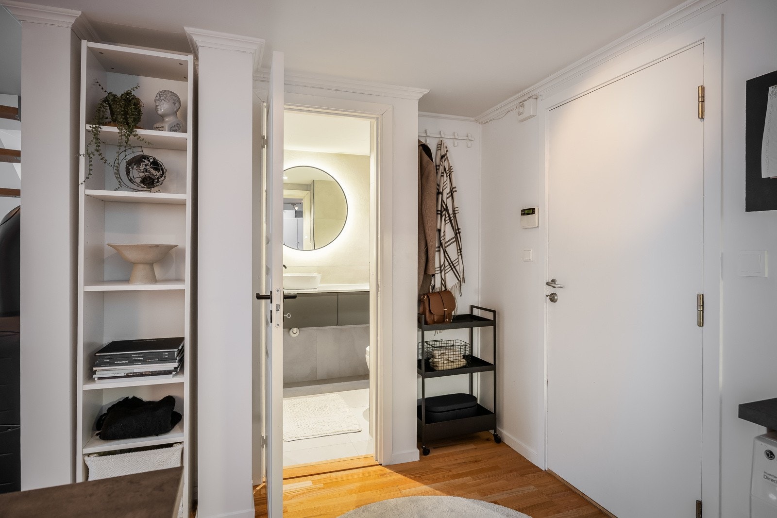 Lekkert bad like ved entréen med praktiske lagringsnisjer på hver side. Galleribilde