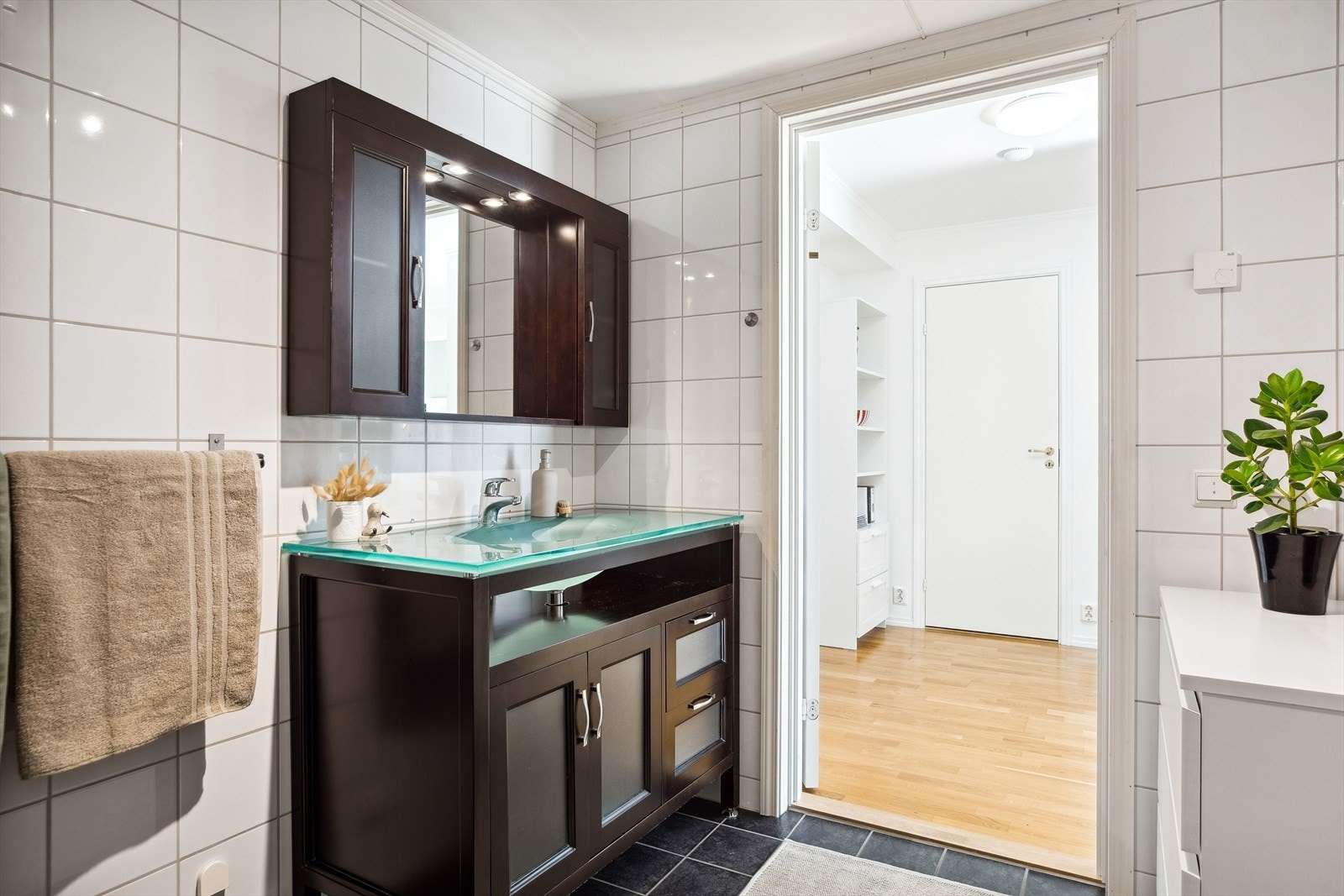 Baderommet er velutstyrt med herlig varme i gulv, moderne innredning, dusjhjørne med innfellbare dører og opplegg for vaskemaskin. Galleribilde