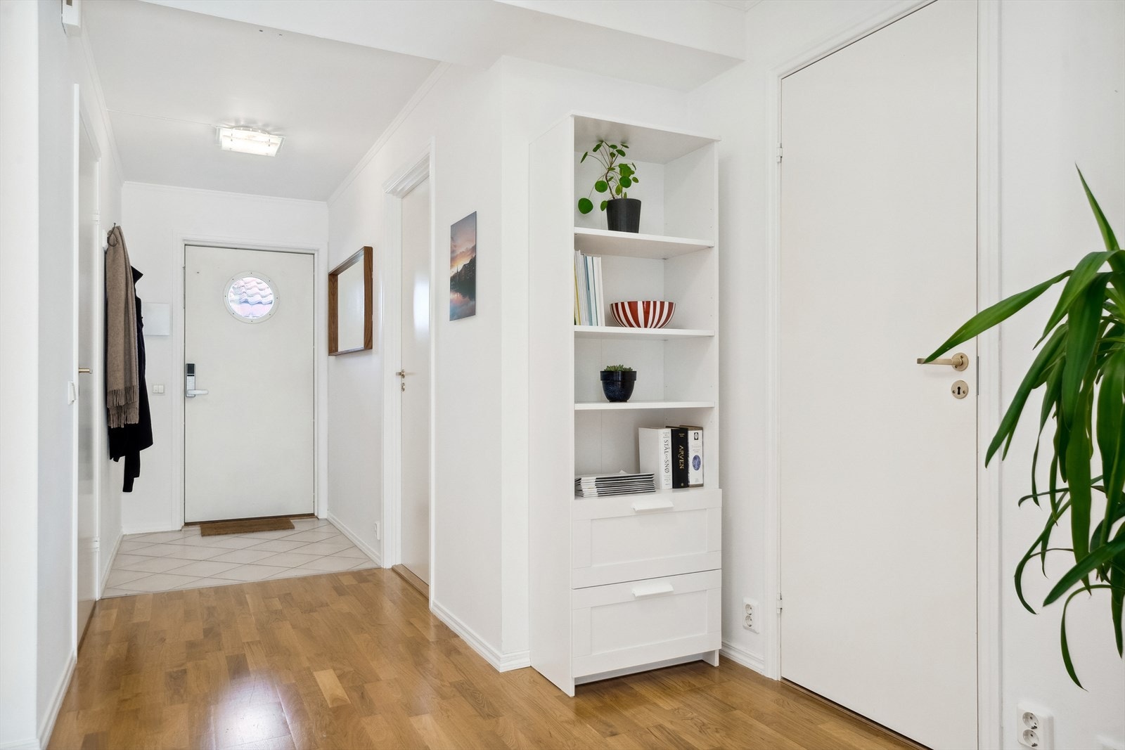 Forbi inngangsdøren er det en romslig entré/gang, med god oppbevaringsplass. Det er flislagt rett innenfor ytterdøren, noe som er praktisk med tanke på bevaring av området. Rommet gir adkomst til øvrige rom, samt naturlig overgang til boligens stue. Galleribilde